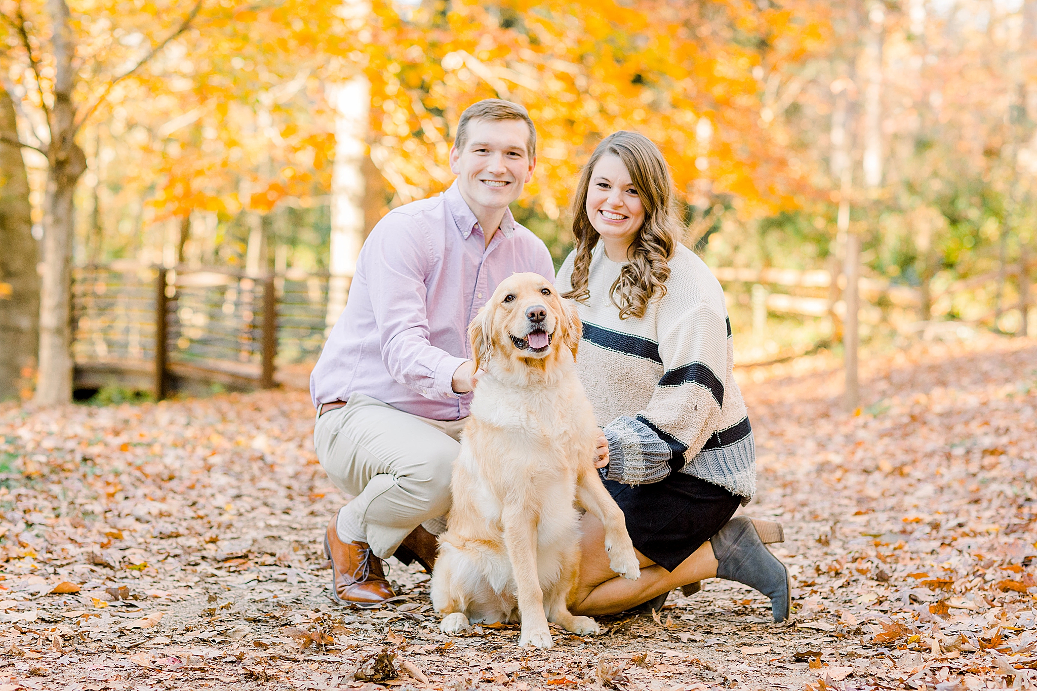 engaged couple laughs during engagement photos with dog