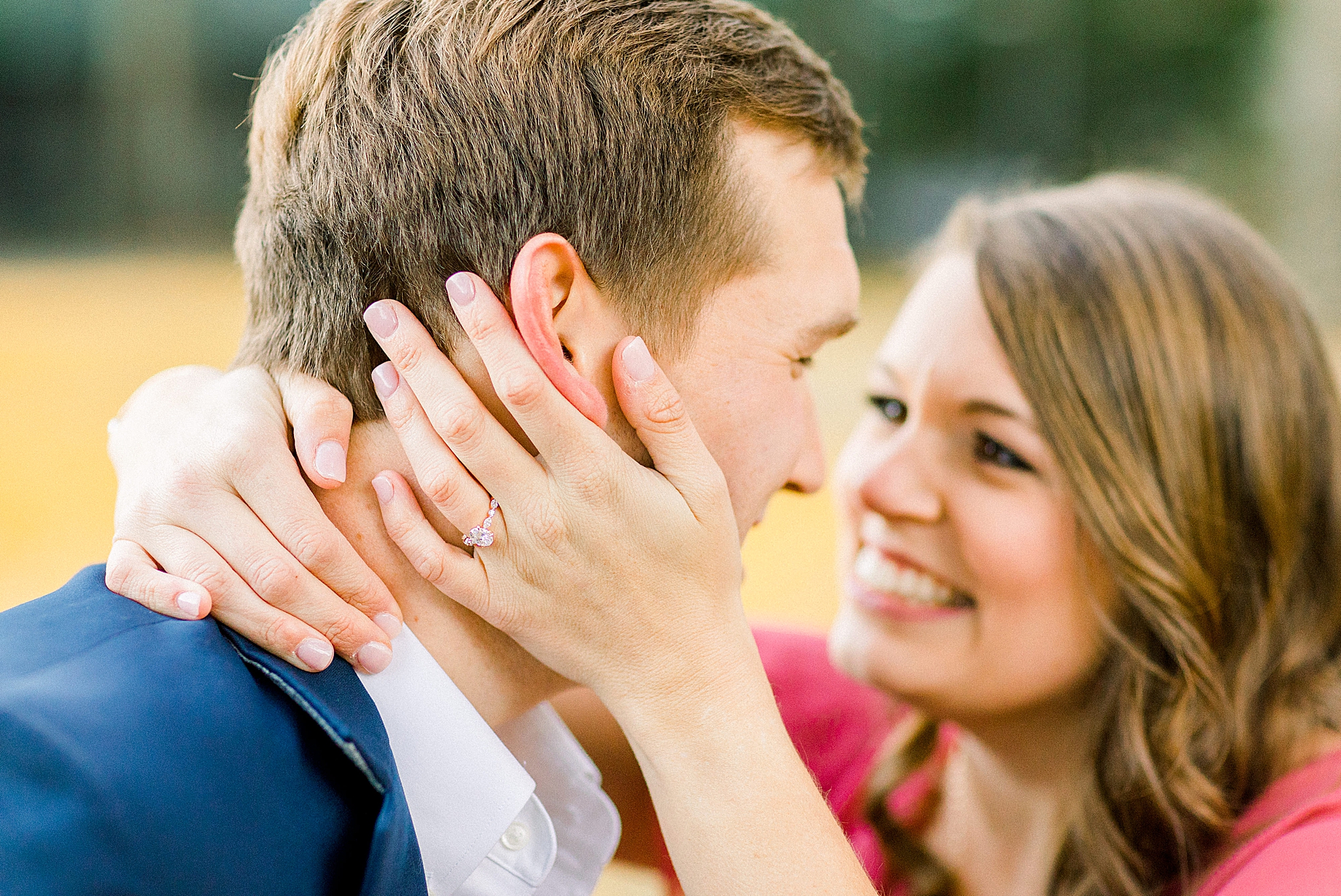 bride holds groom's head showing off diamond ring