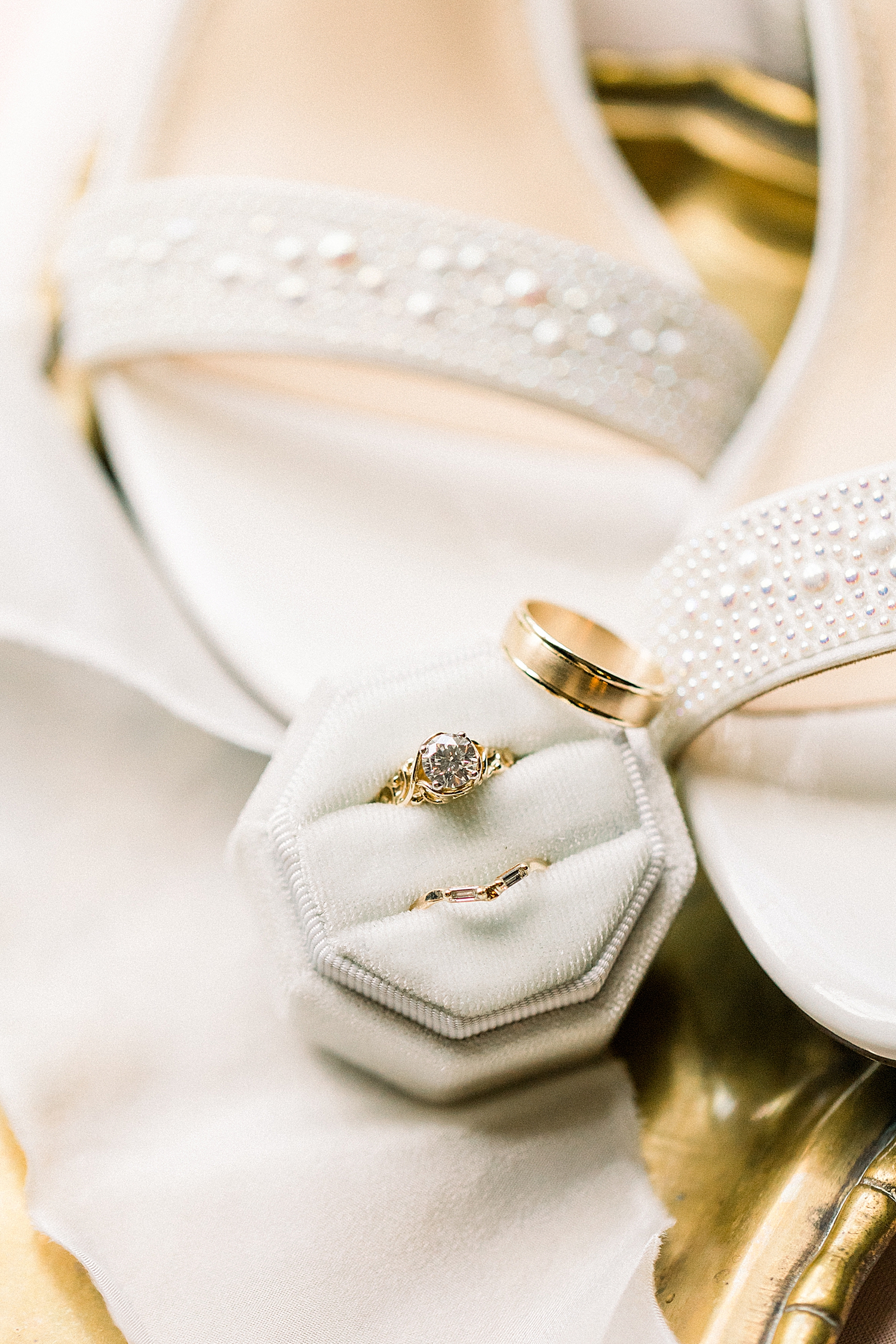 bride's jewelry rests on shoes and ivory ring box