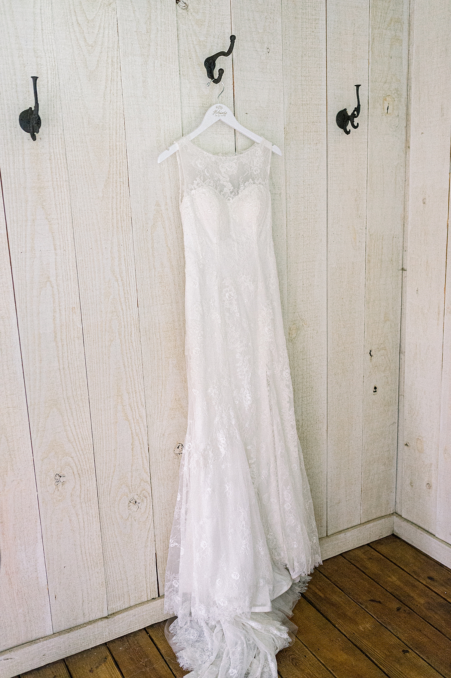 wedding dress hangs on rustic wooden dress at Creekside Meadows