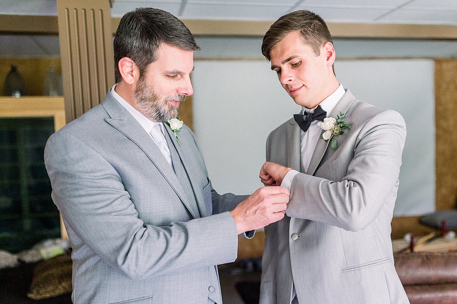 groomsman adjusts groom's cufflinks