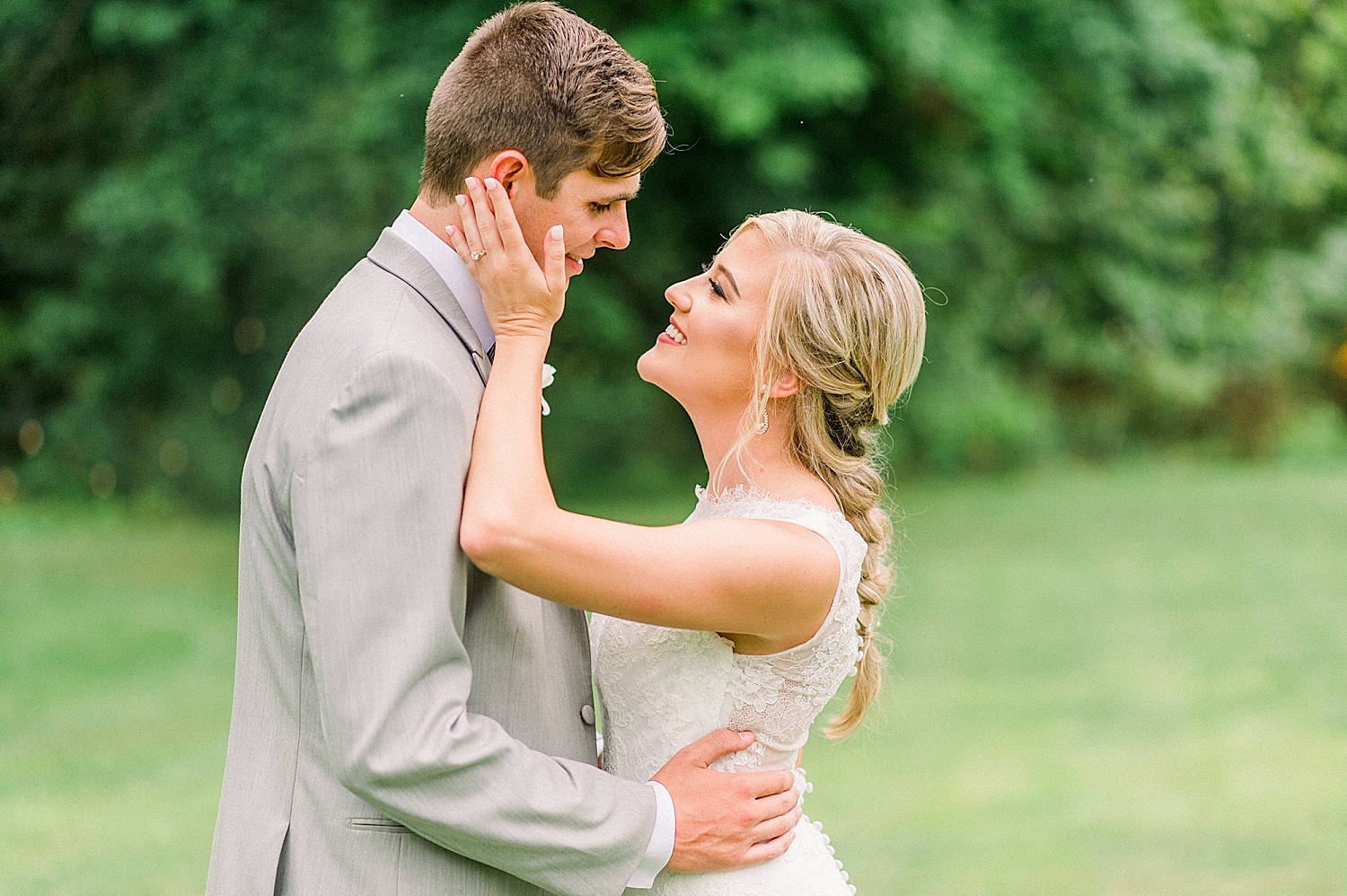 bride holds groom's face during Alabama wedding photos