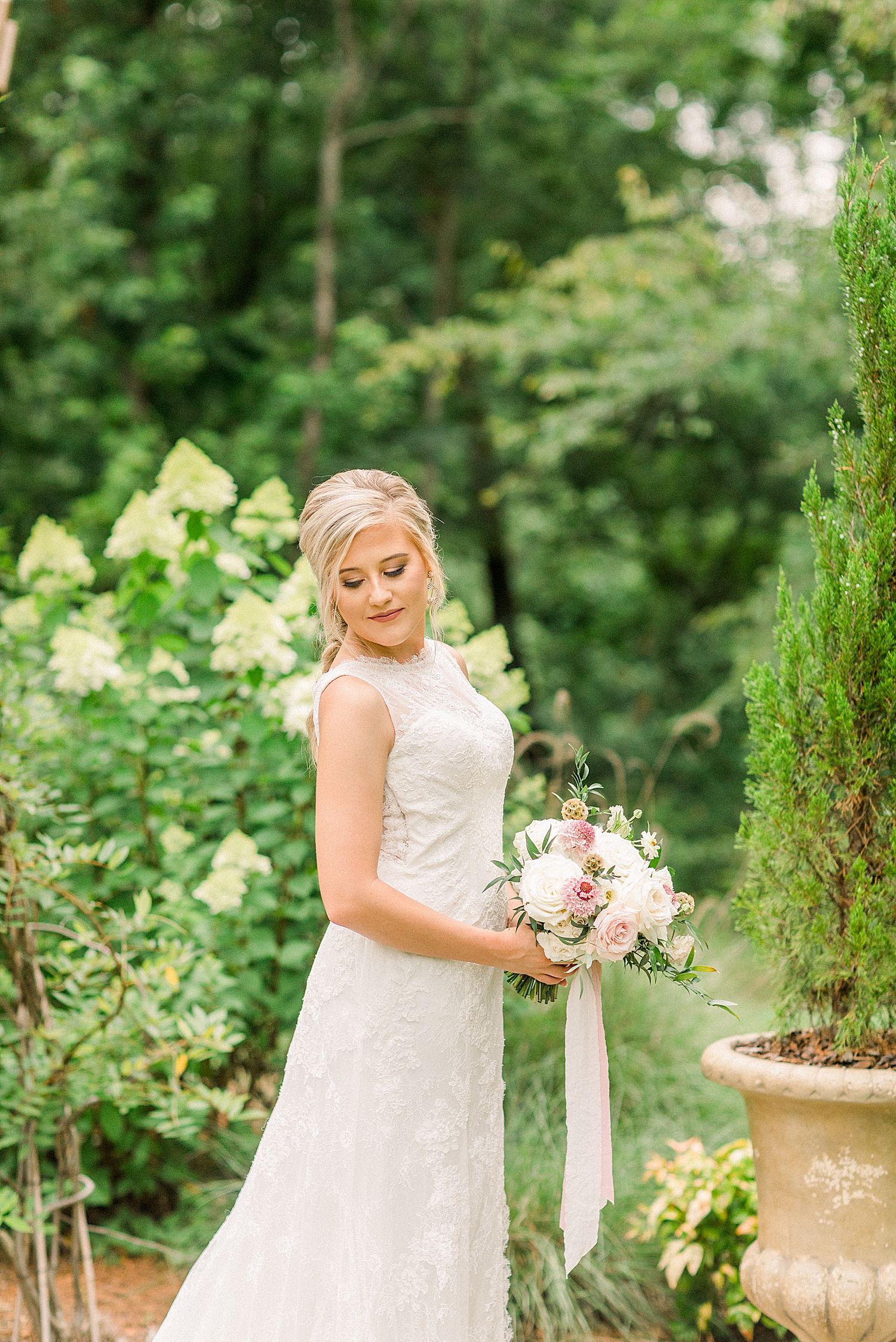 bride holds bouquet and looks over shoulder at Creekside Meadows