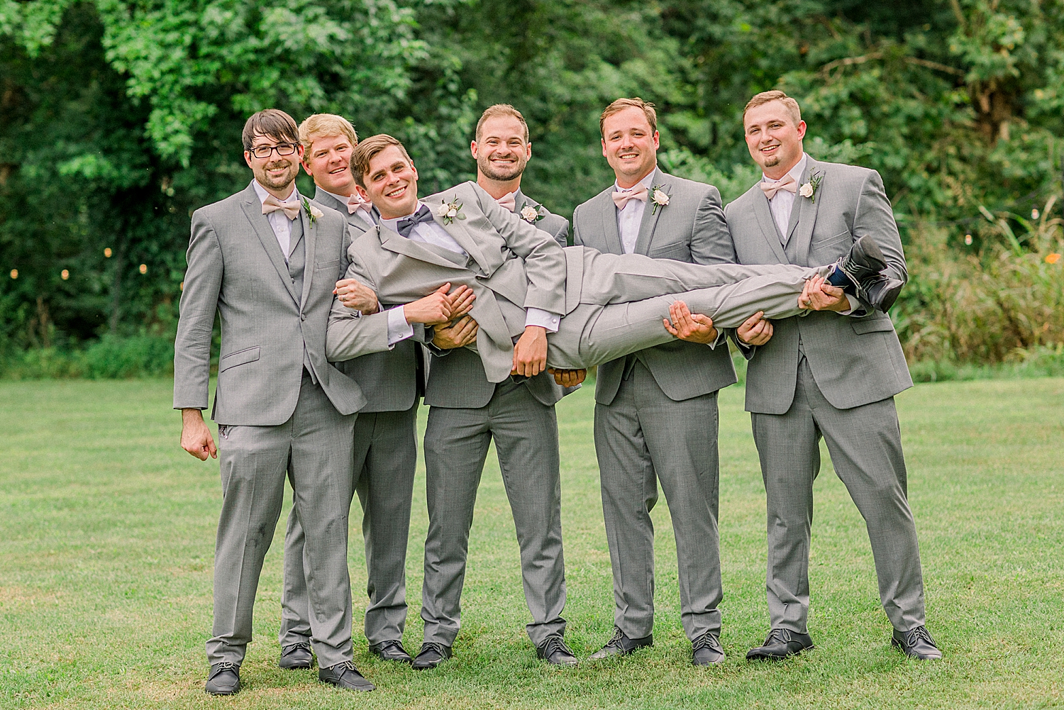 groomsmen hold groom during AL wedding photos