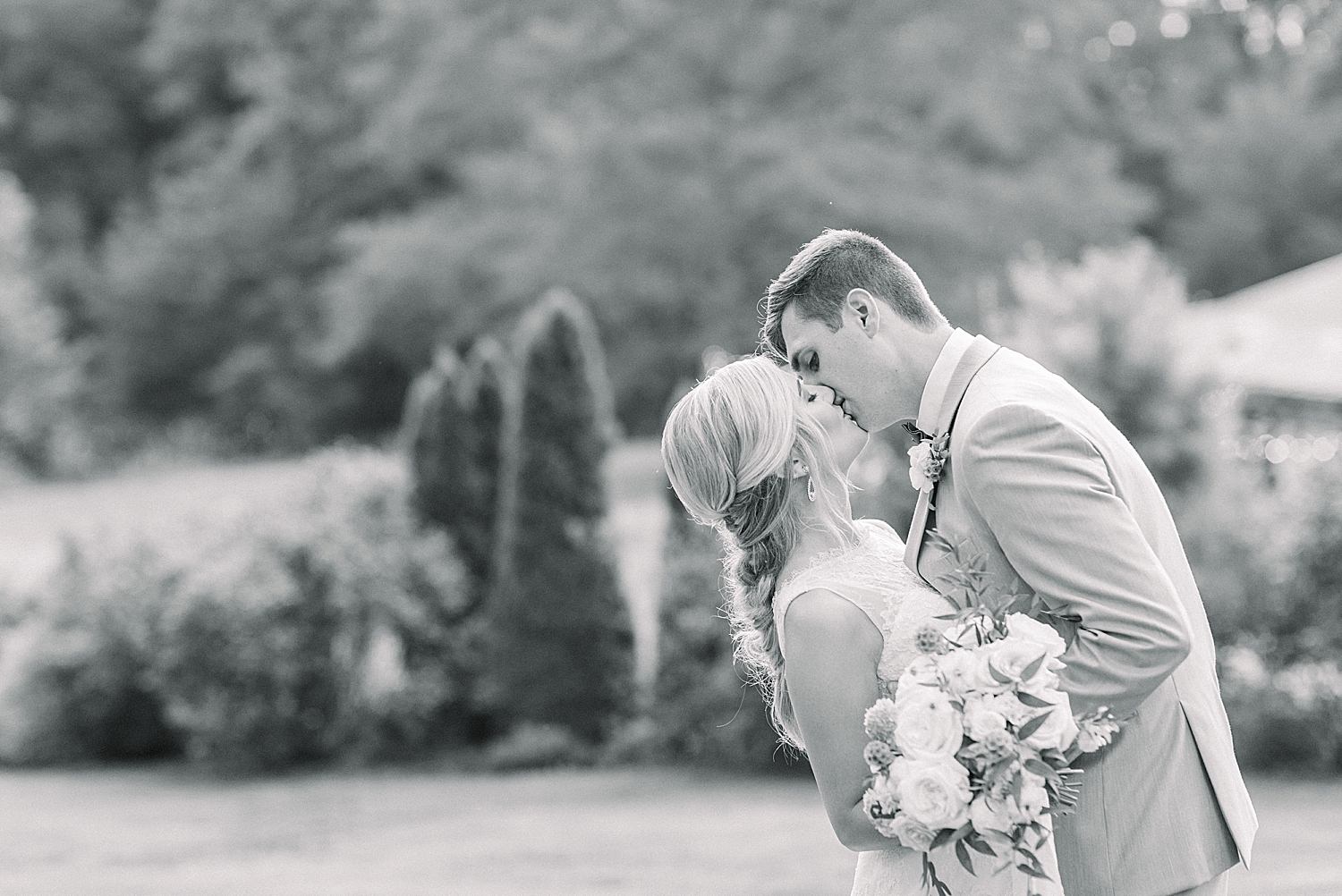 newlyweds kiss during Creekside Meadows wedding photos