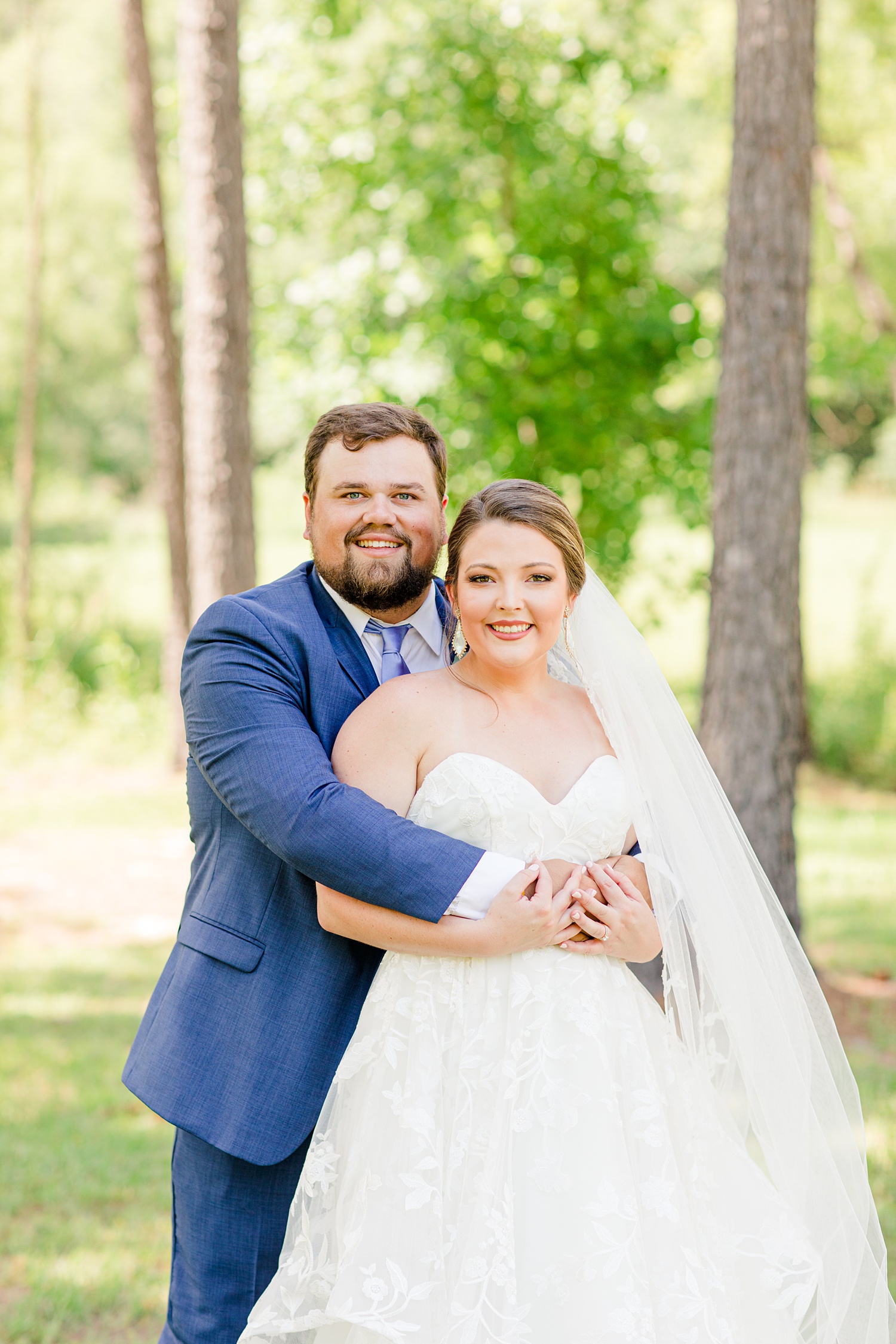 groom hugs bride from behind during Alabama wedding photos