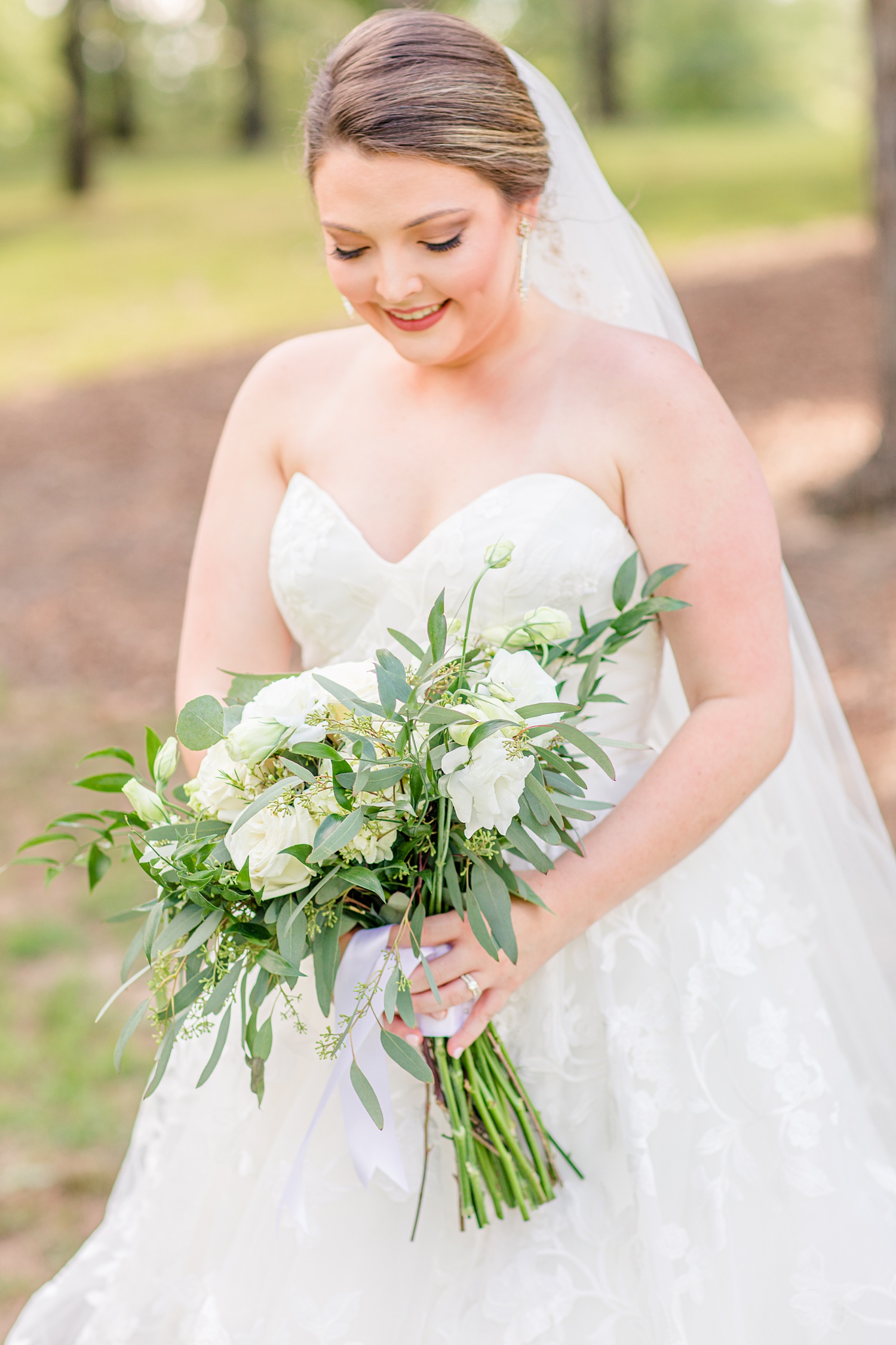 bride looks down at bouquet during wedding portraits at Douglas Manor