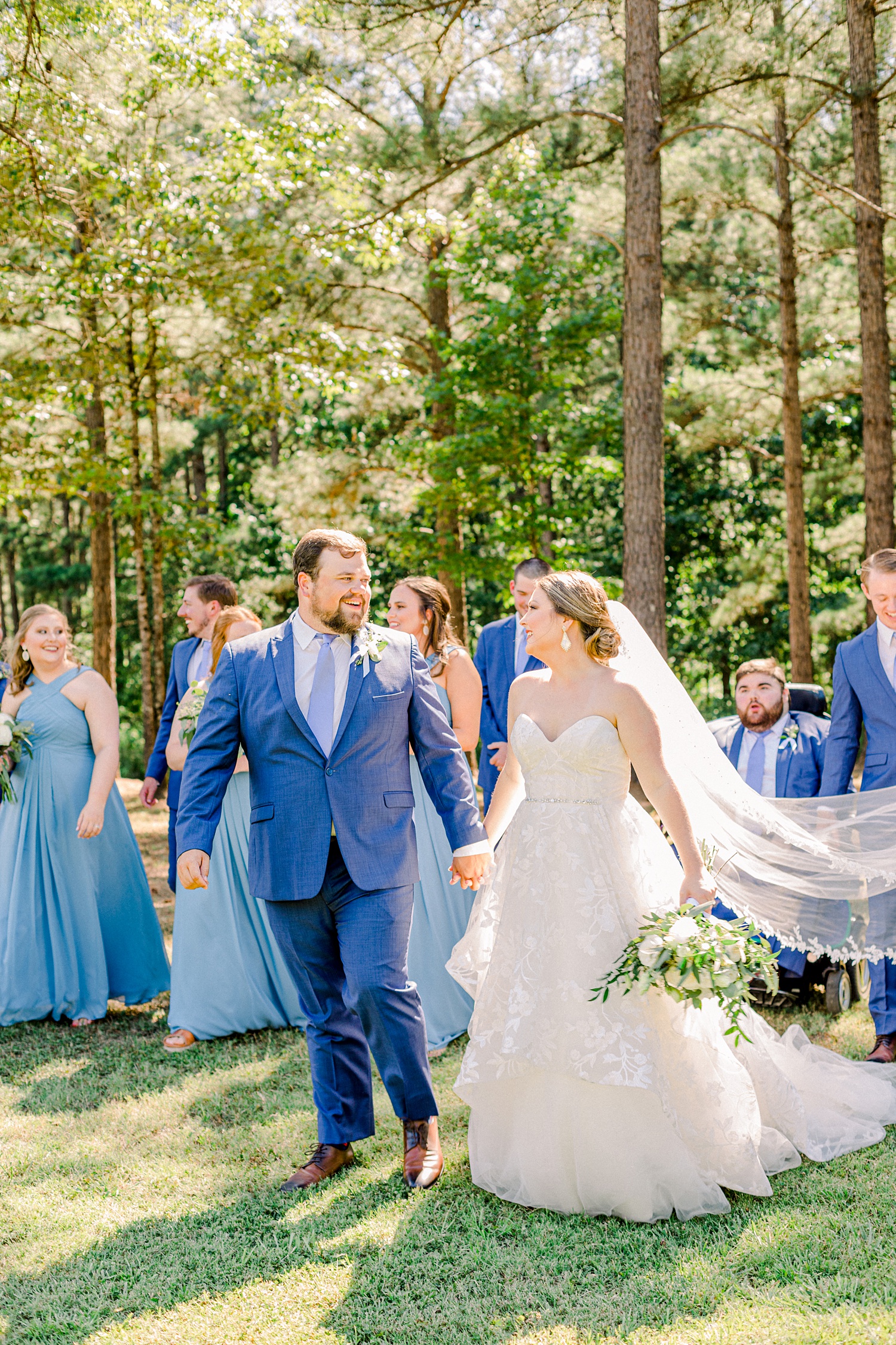 newlyweds walk with bridal party behind them at Douglas Manor