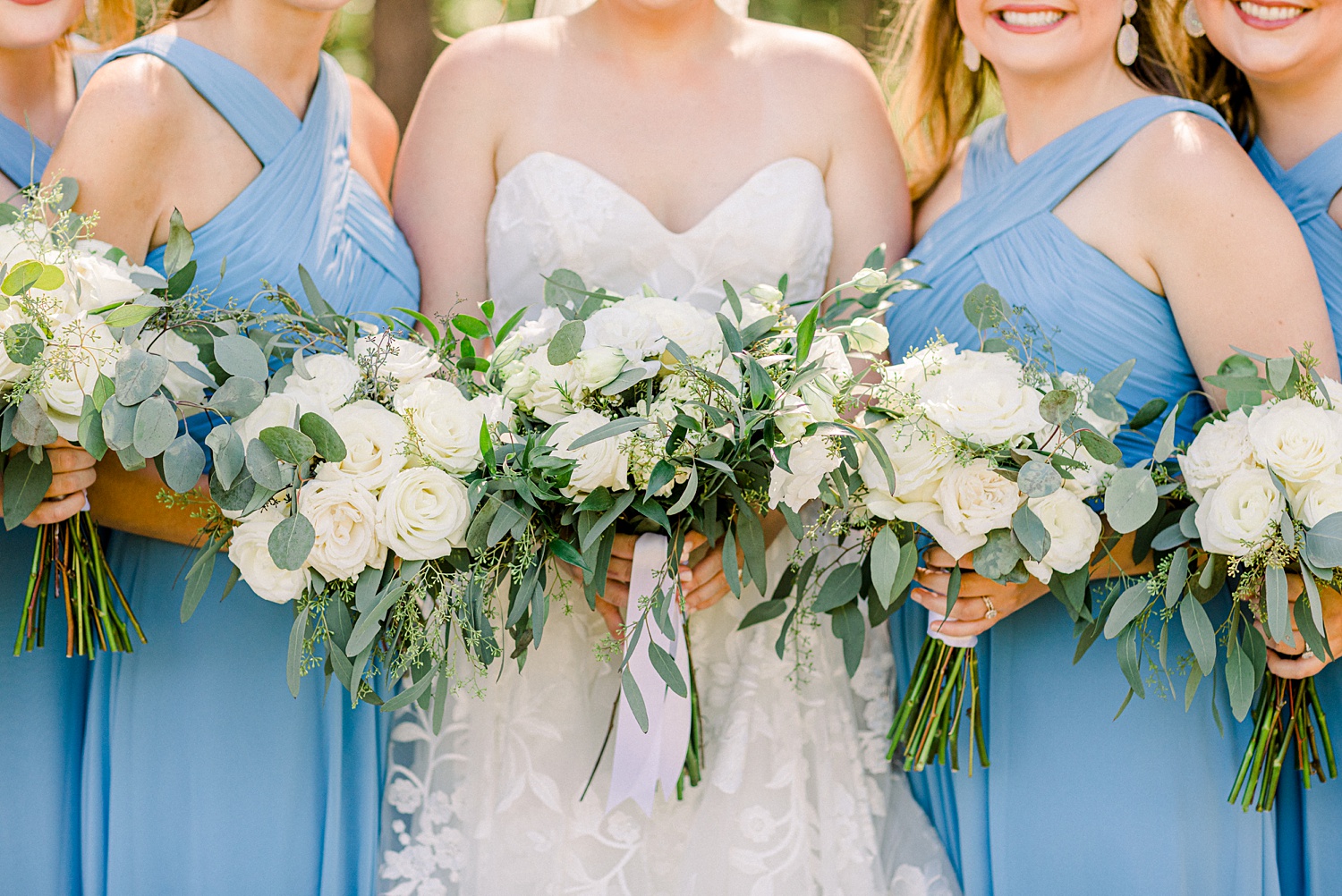 bride and bridesmaids hold all-white bouquets during AL wedding
