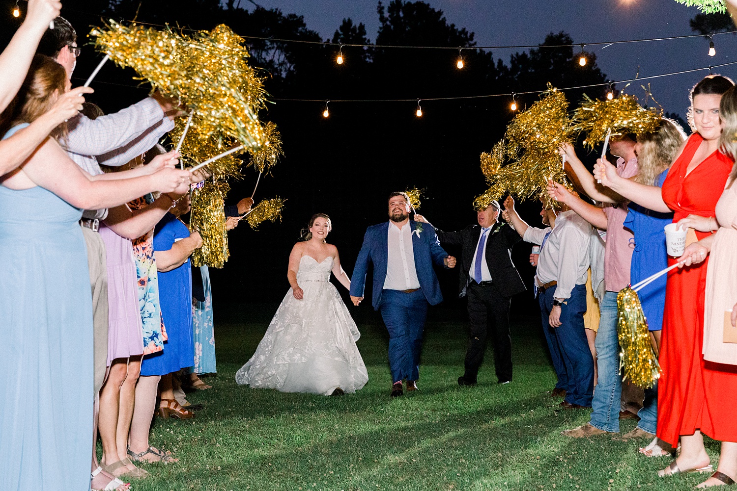 newlyweds leave wedding reception during pom-pom exit at night
