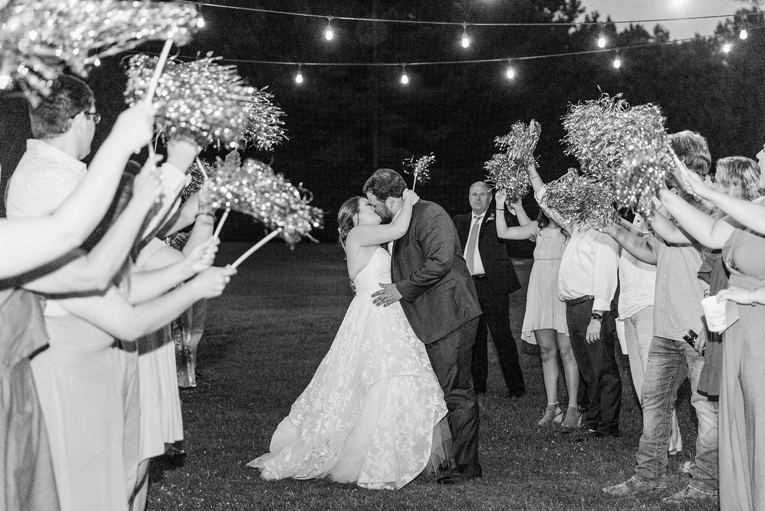 newlyweds leave wedding reception during pom-pom exit at night