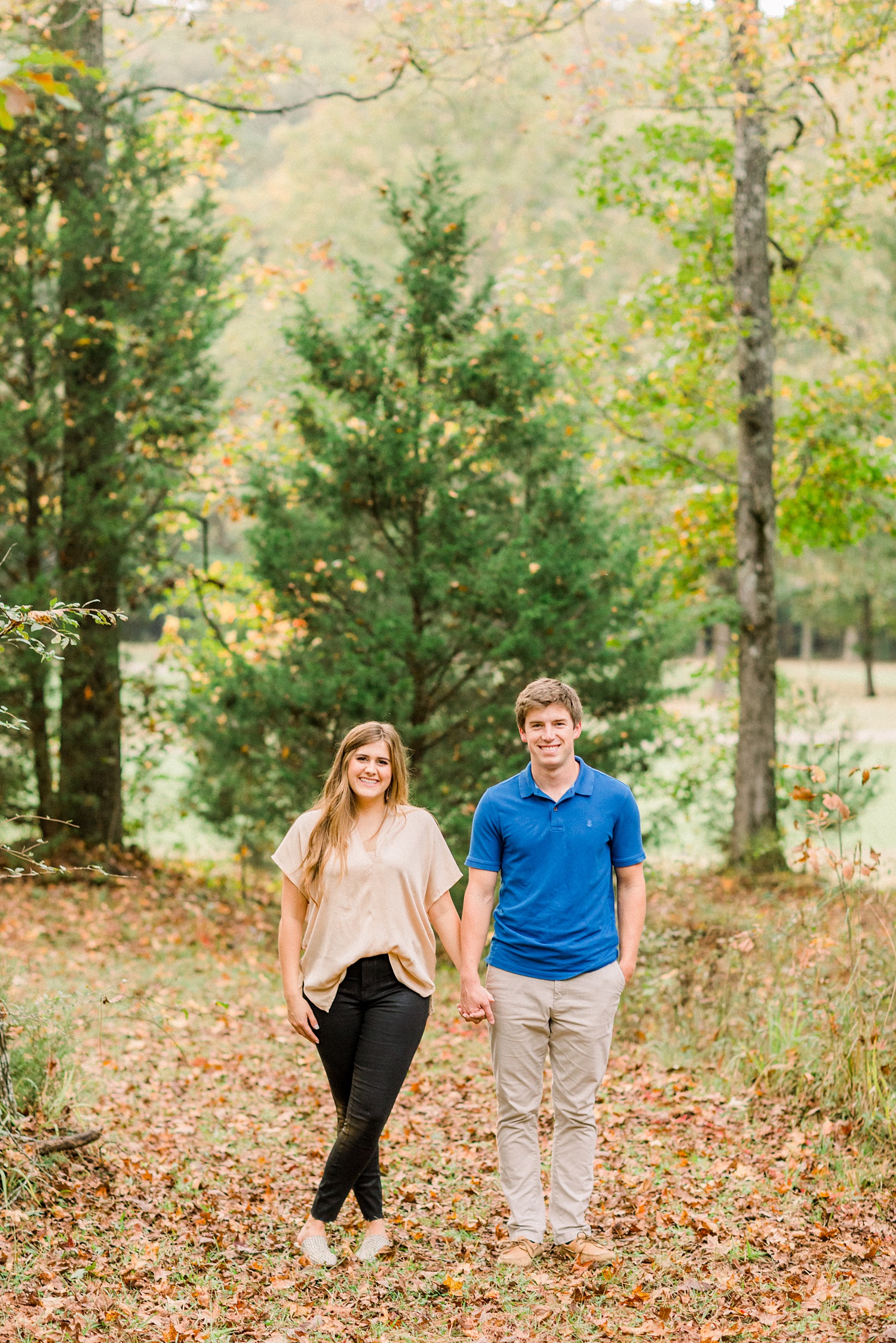 couple holds hands walking through Oak Mountain State Park