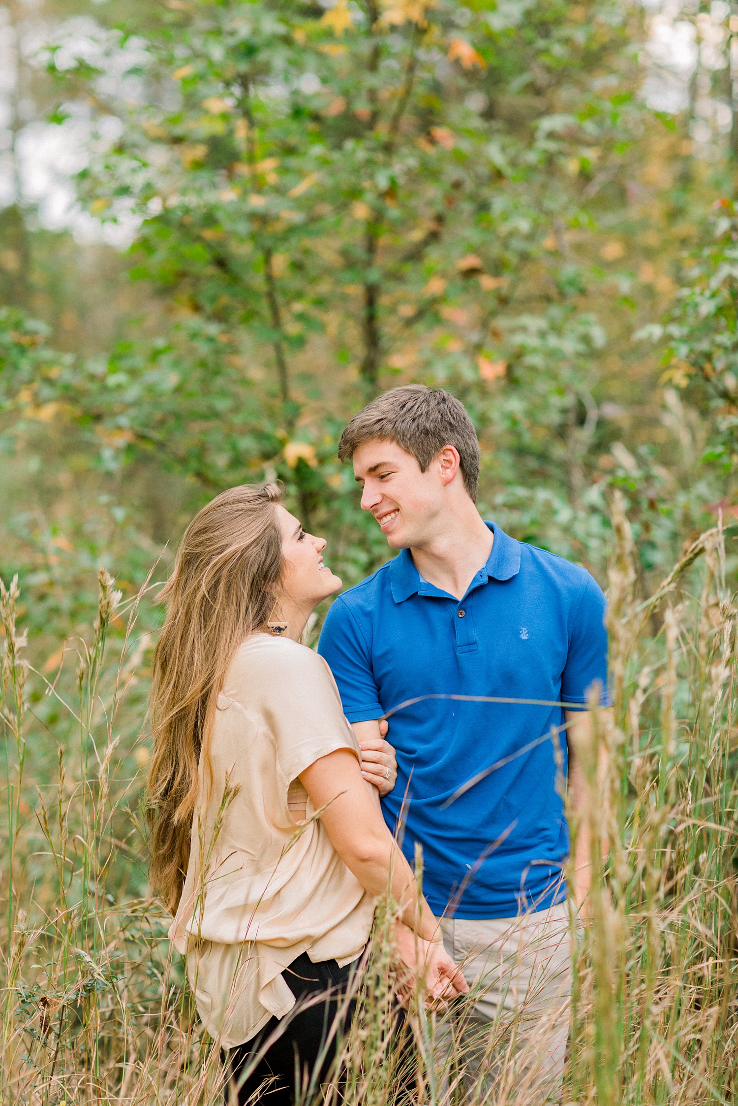 bride and groom laugh together in grass during Birmingham AL engagement session