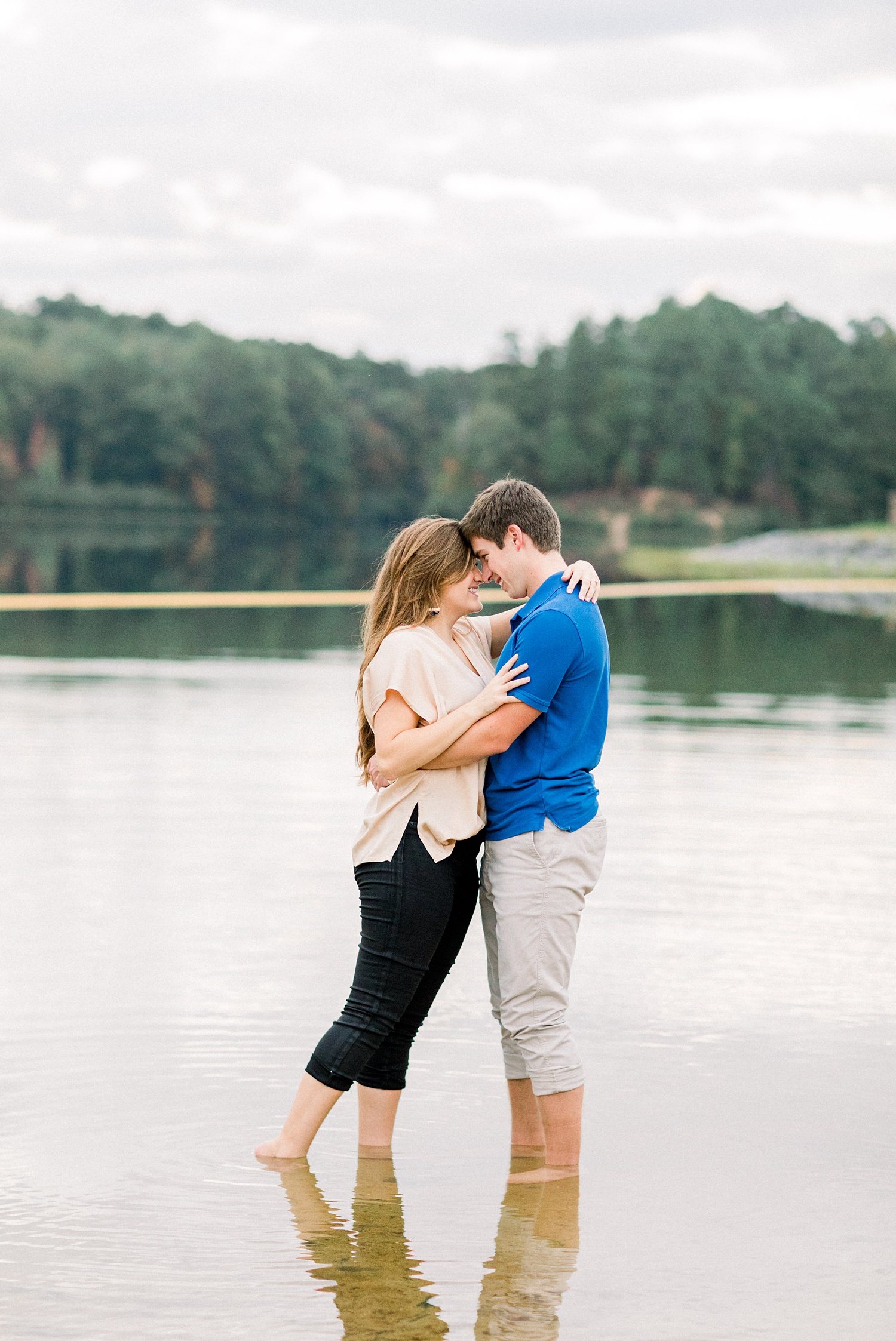 engaged couple stands in lake at Oak Mountain State Park