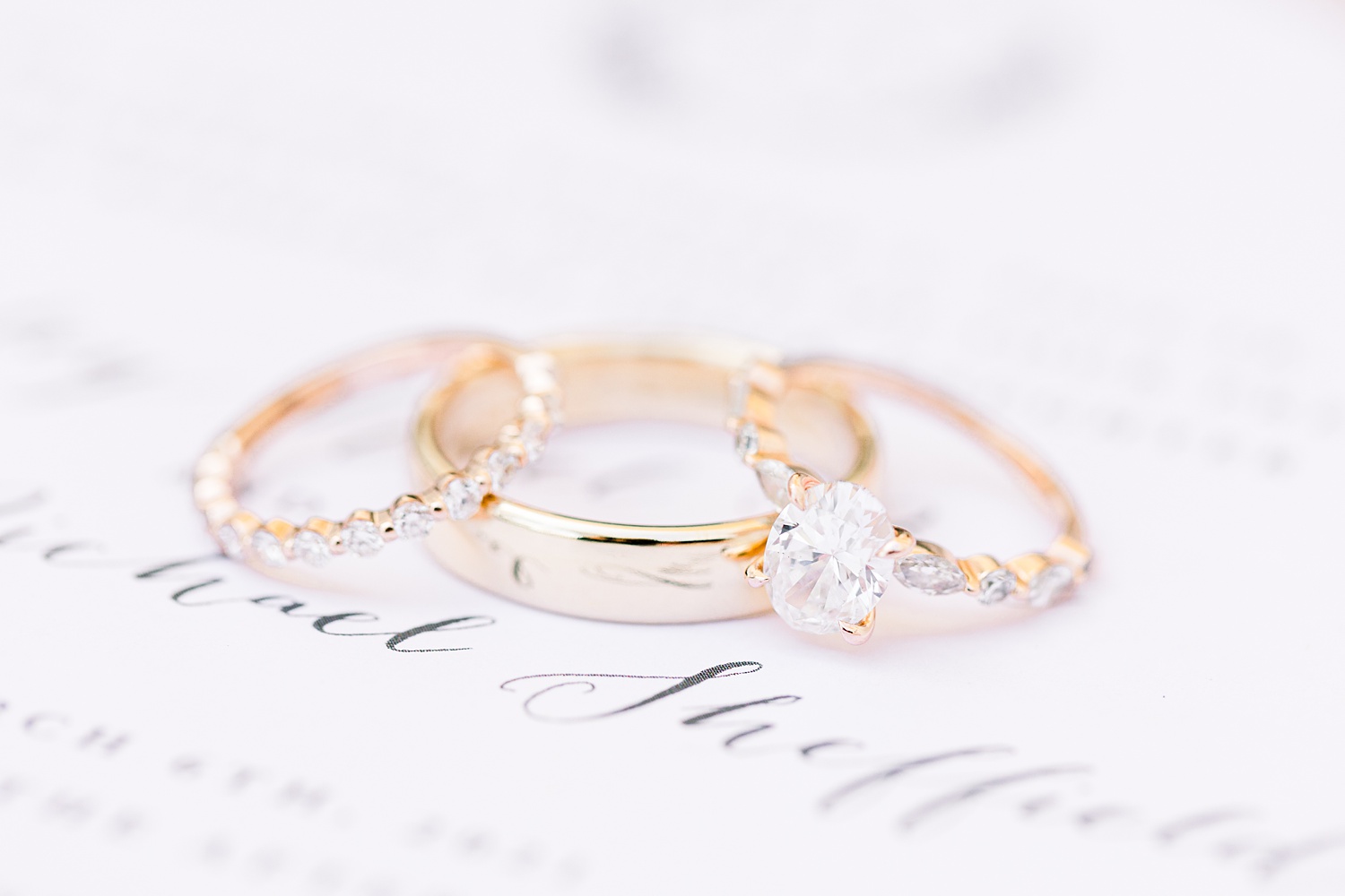wedding rings rest on wedding invitation