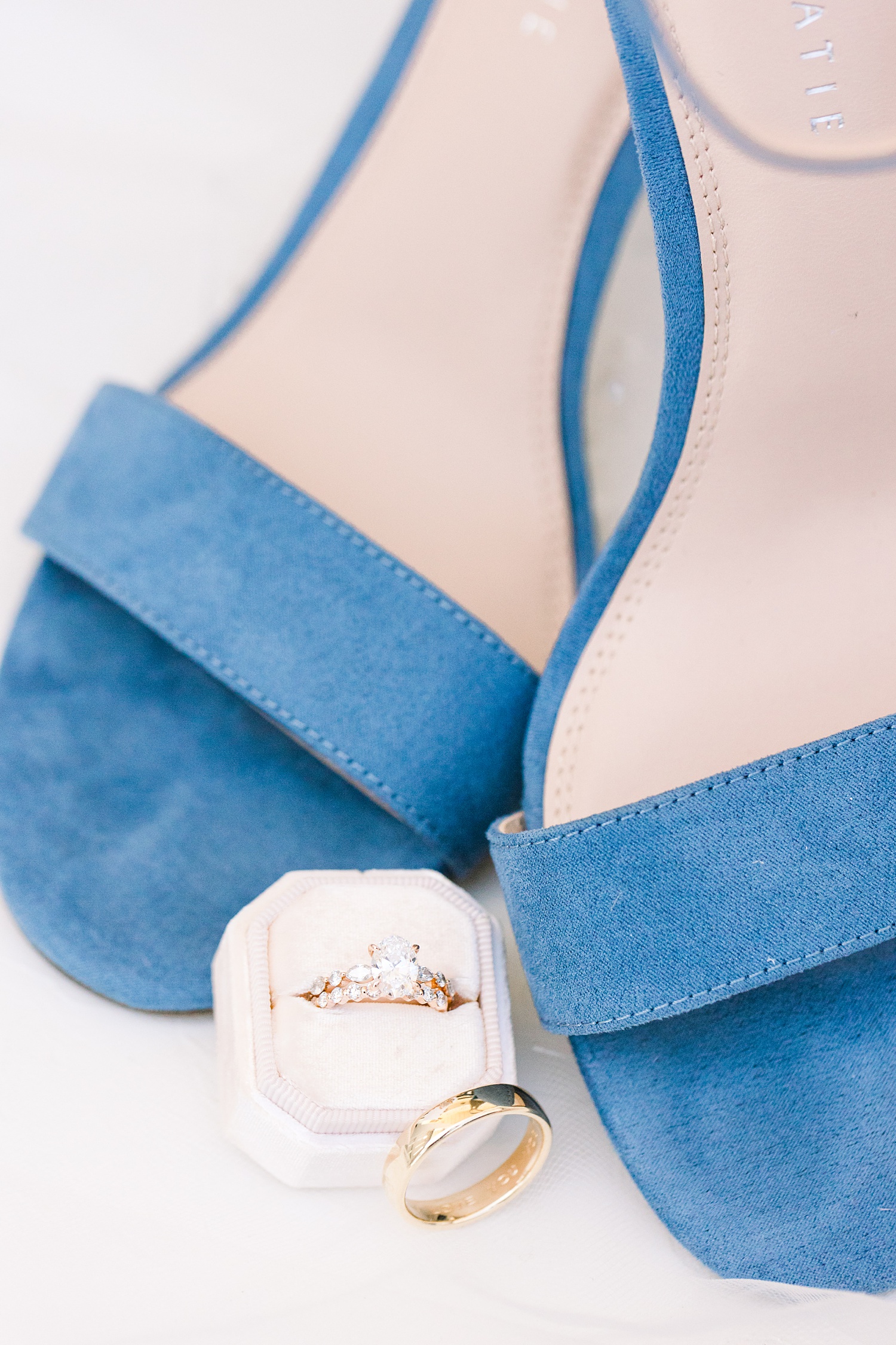 bride's blue shoes next to engagement ring