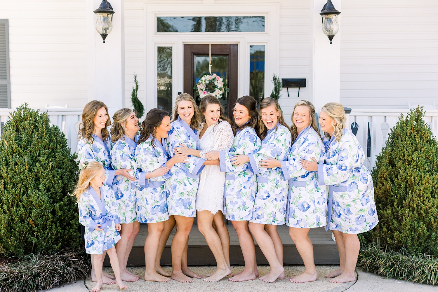 bride poses with bridesmaids in matching blue robes