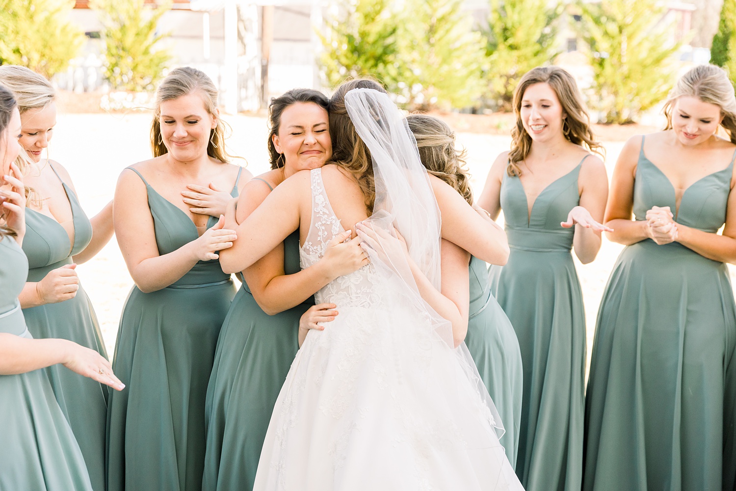 bride hugs bridesmaids during first look