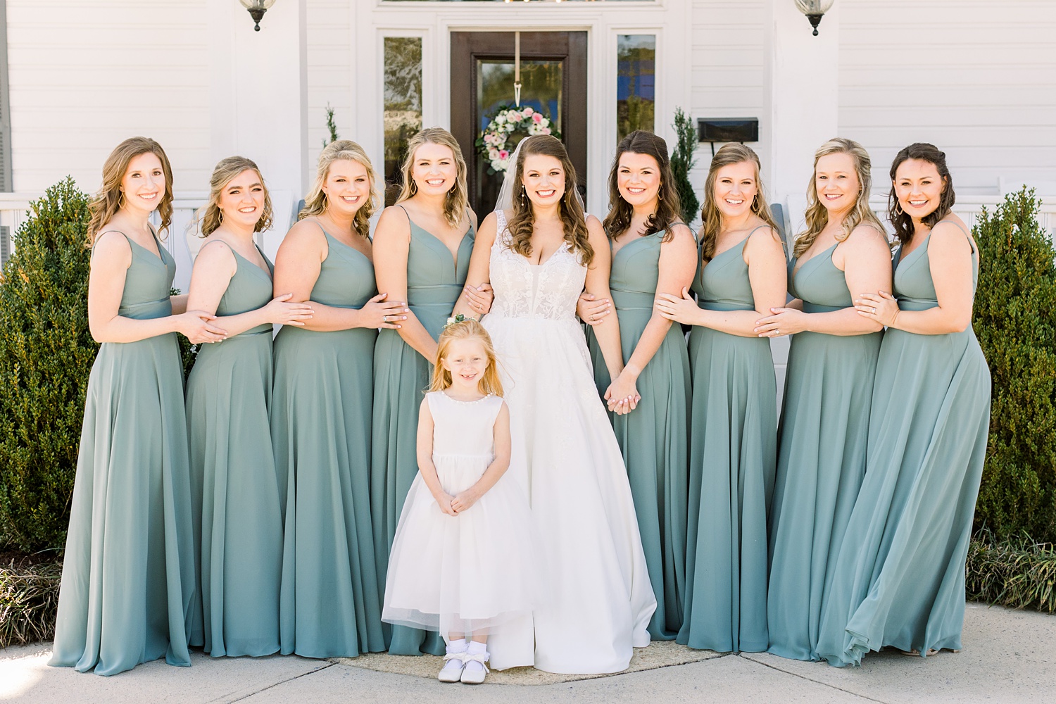 Alabama bride poses with bridesmaids in green gowns before Camelot Manor wedding