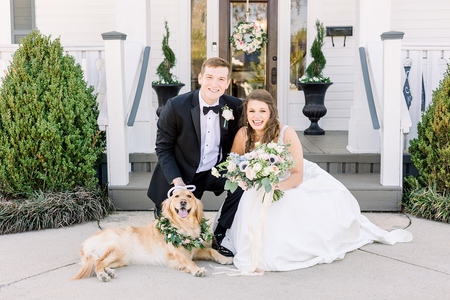 bride and groom pose with dog outside Camelot Manor