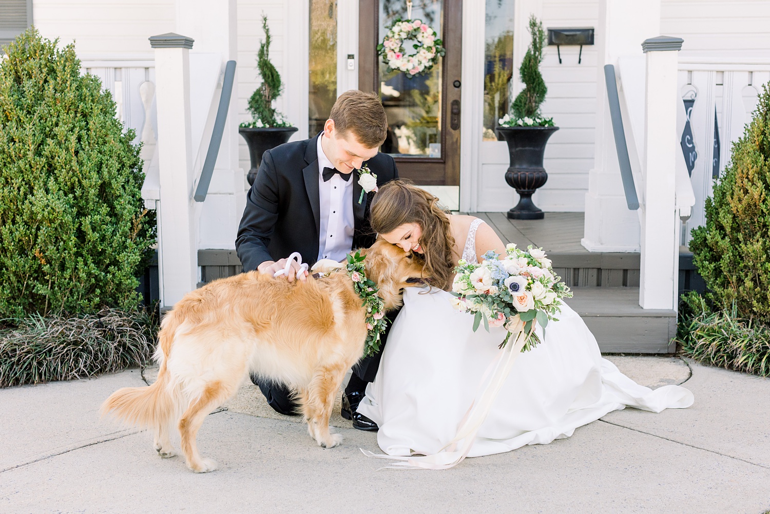 bride leans down to hug dog during Alabama wedding portraits