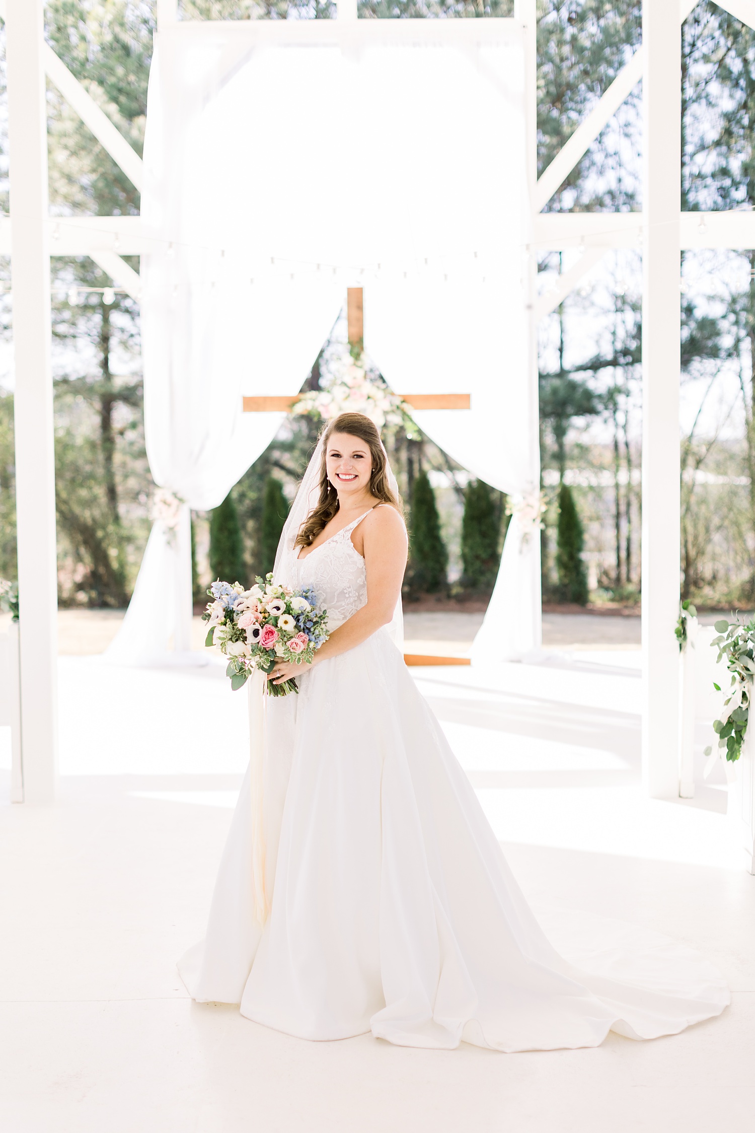 Camelot Manor bridal portrait of bride in front of cross