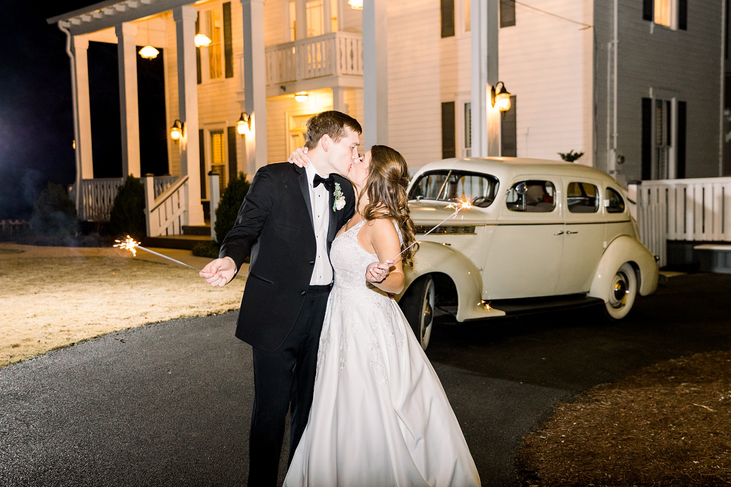 newlyweds pose by classic car during Alabama wedding reception