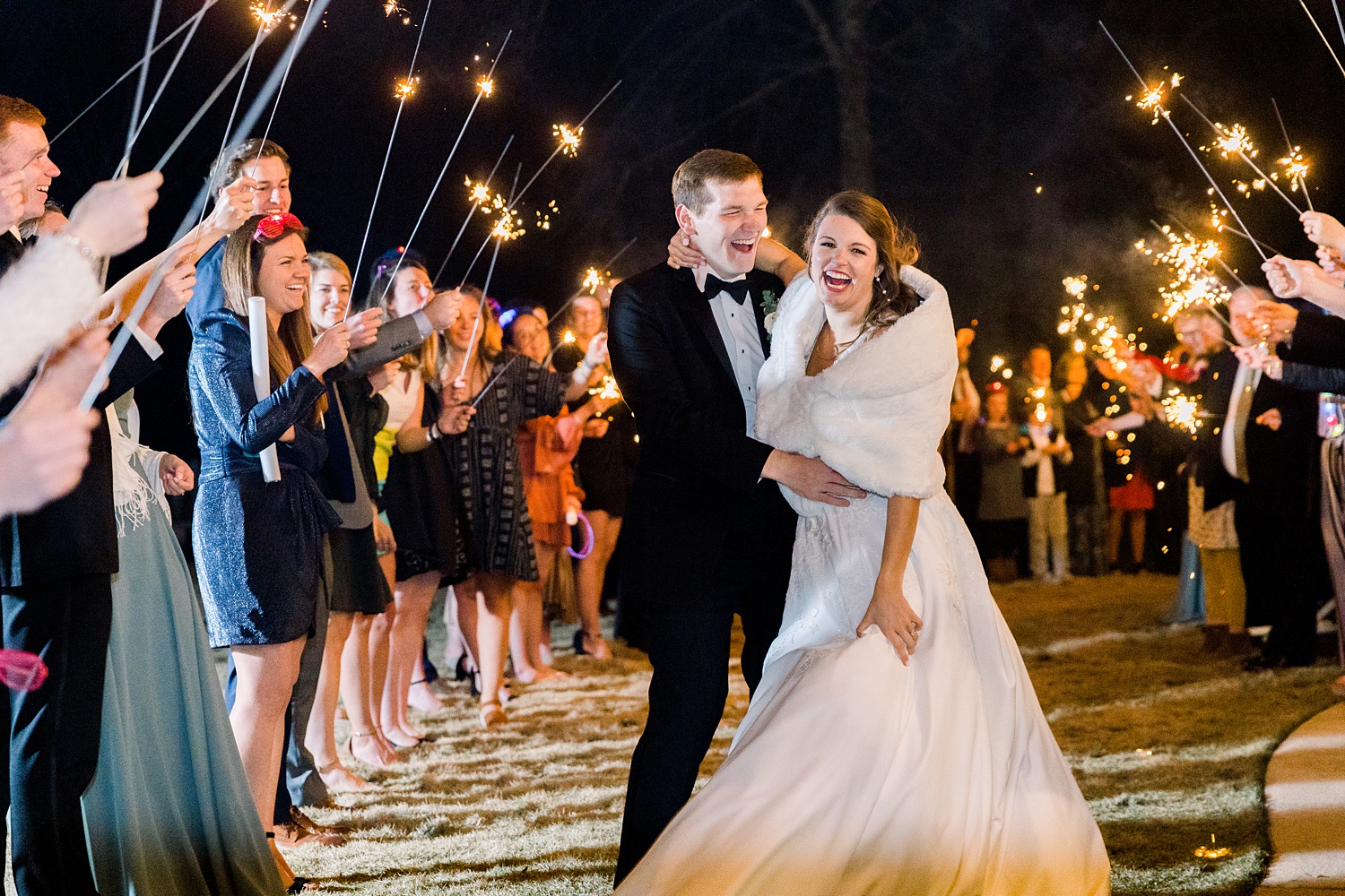 bride and groom laugh during sparkler exit from Alabama wedding reception