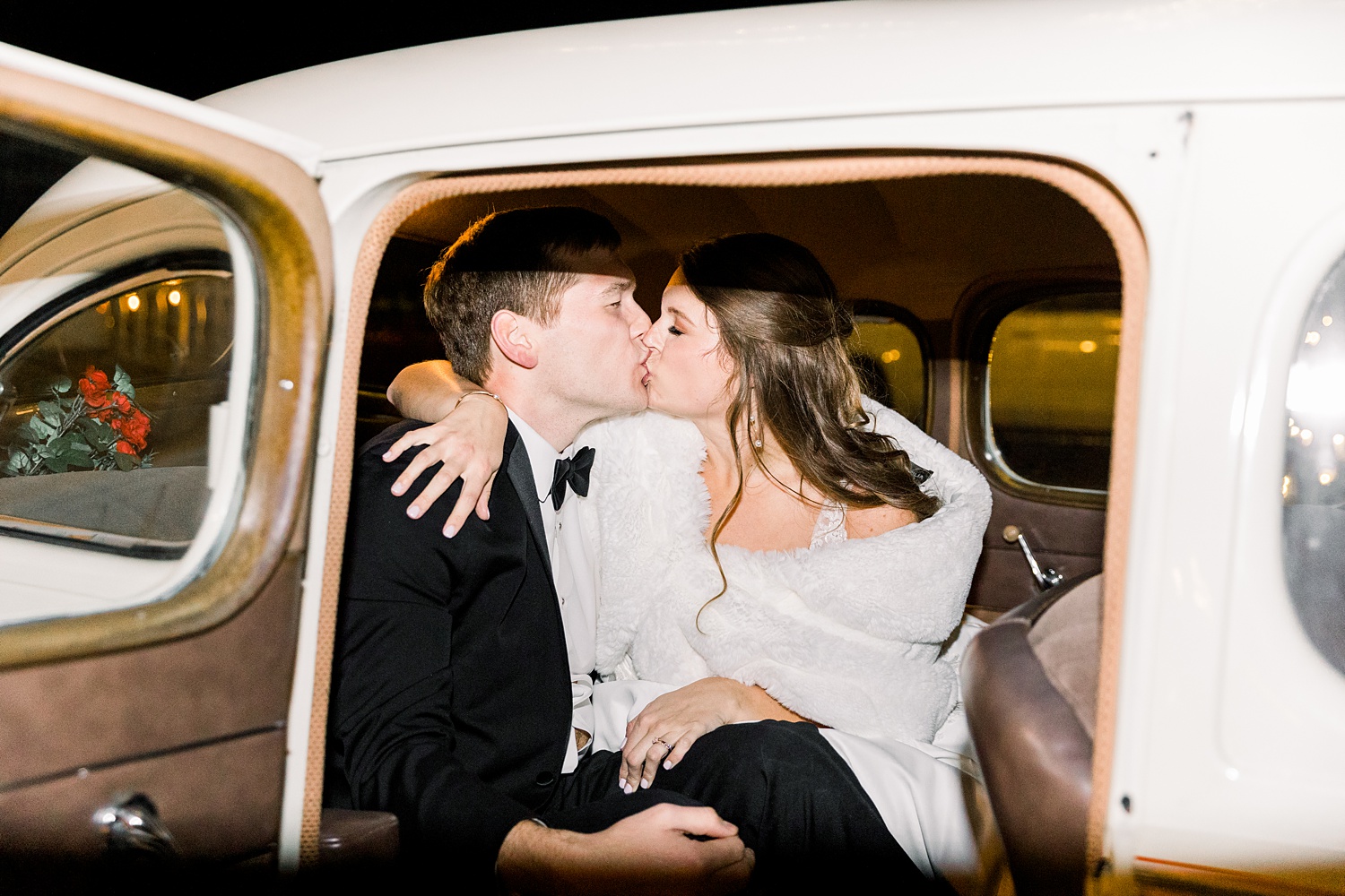 bride and groom kiss in classic car after Alabama wedding reception