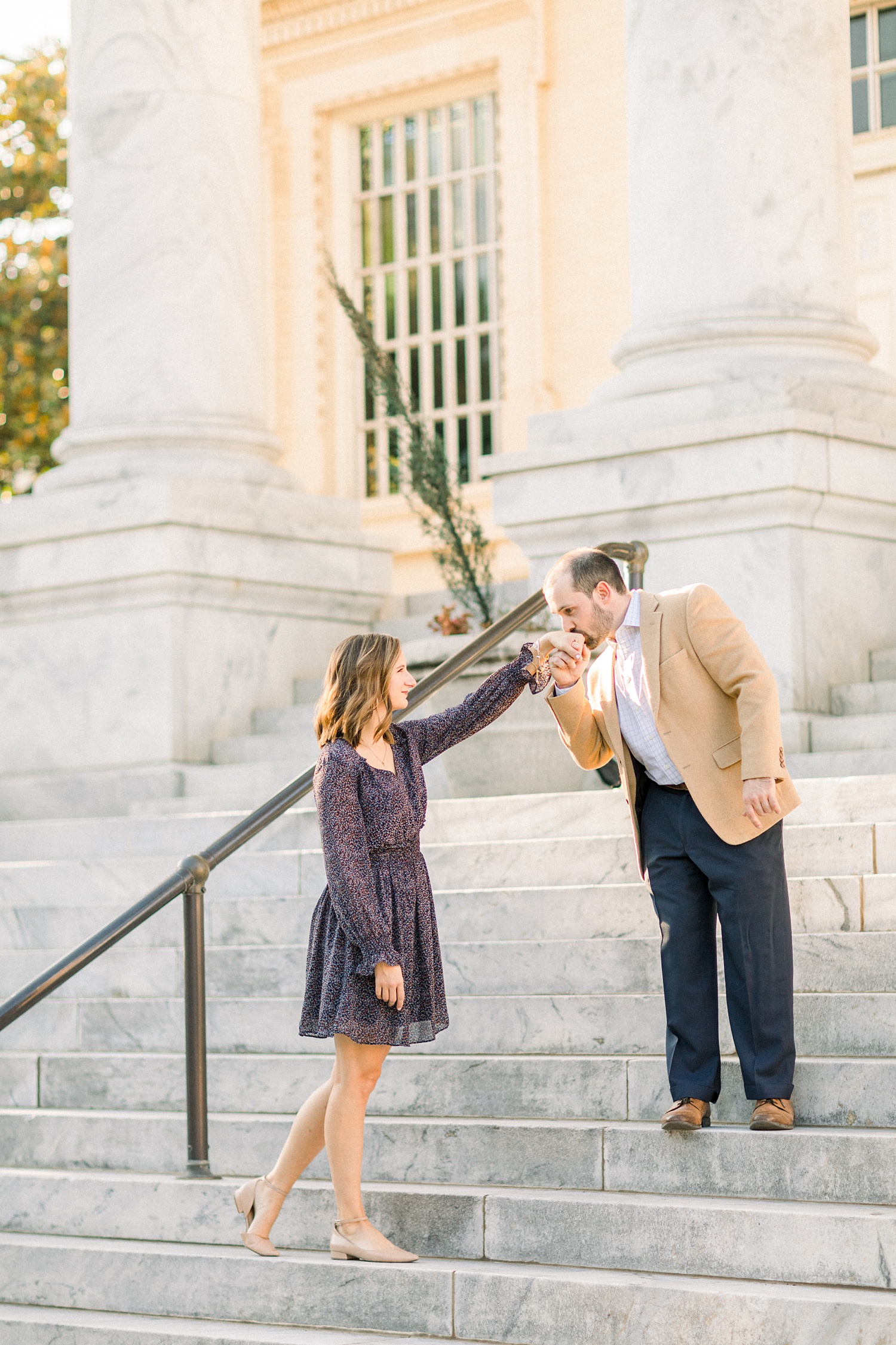 groom kisses bride's hand during Downtown Birmingham engagement session