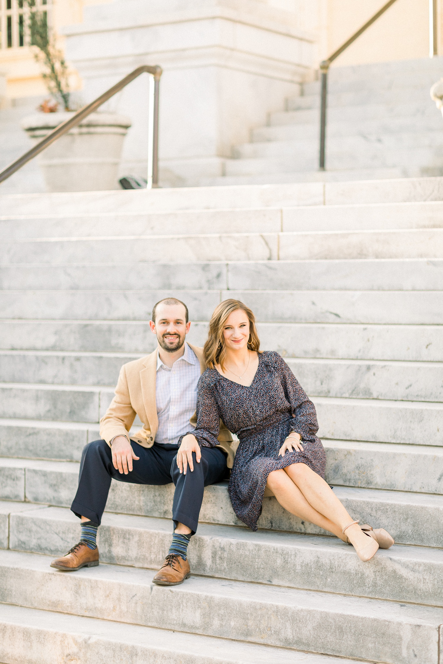 couple sits on steps during Downtown Birmingham engagement photos