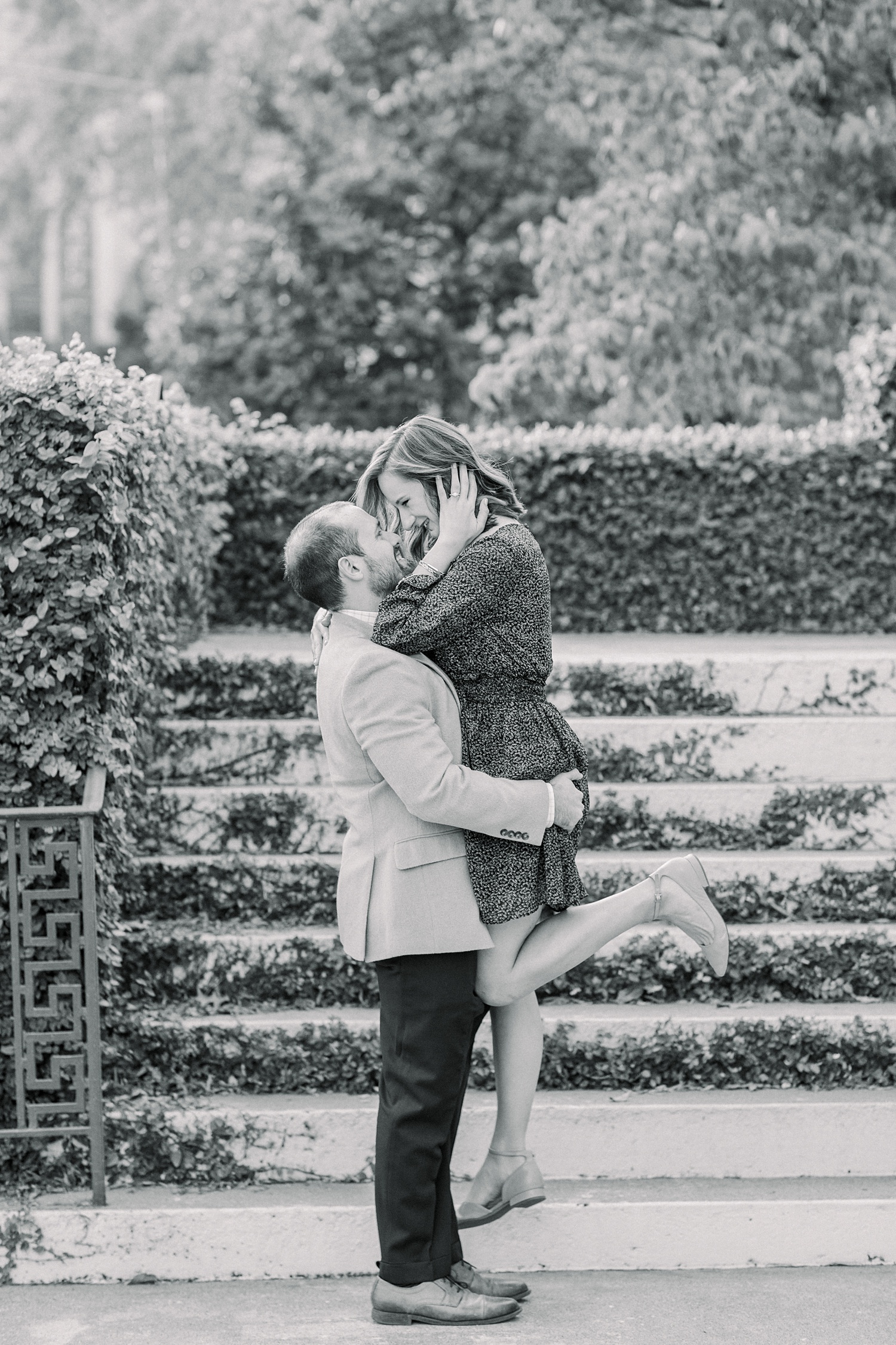 groom lifts bride up during Downtown Birmingham engagement photos