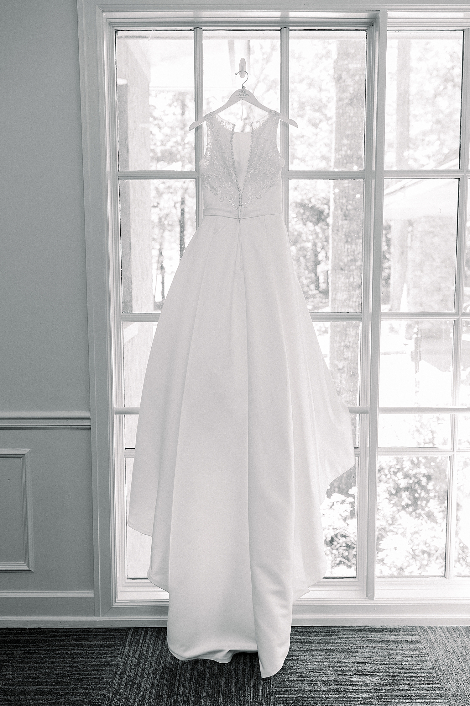 bride's dress hangs in window at Riverchase Country Club