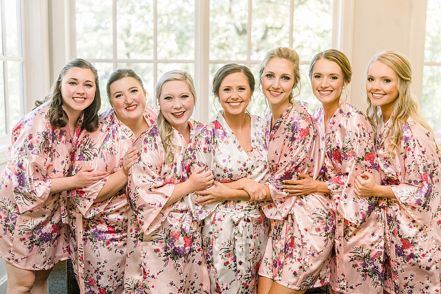 bride and bridesmaids hug in matching robes