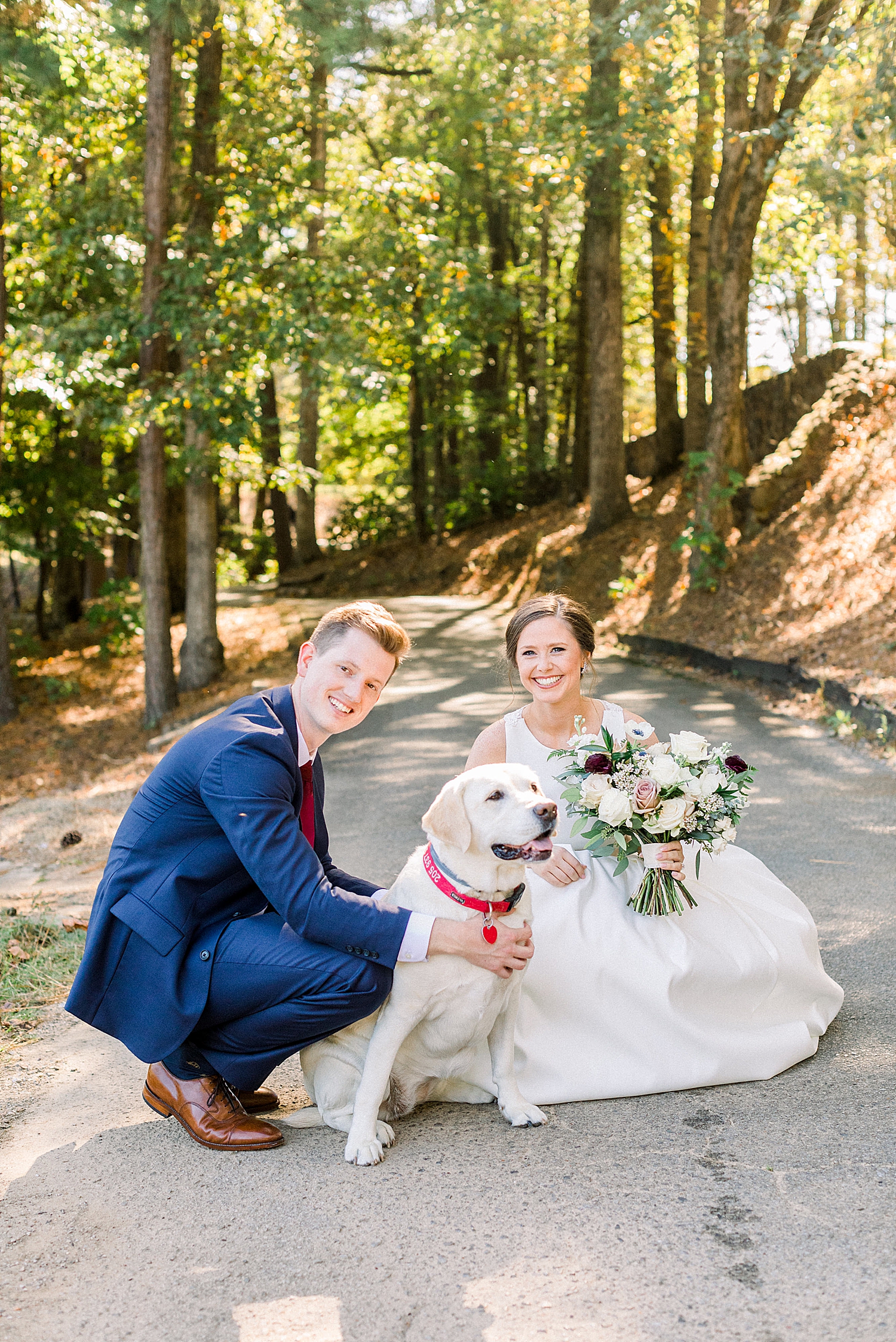 bride and groom pose with dog during first look