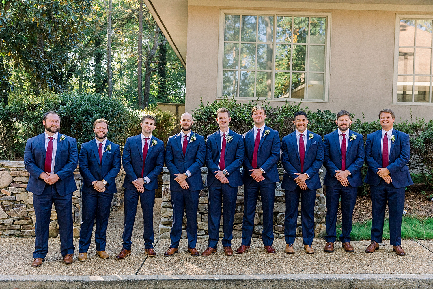 groom poses with groomsmen in navy suits