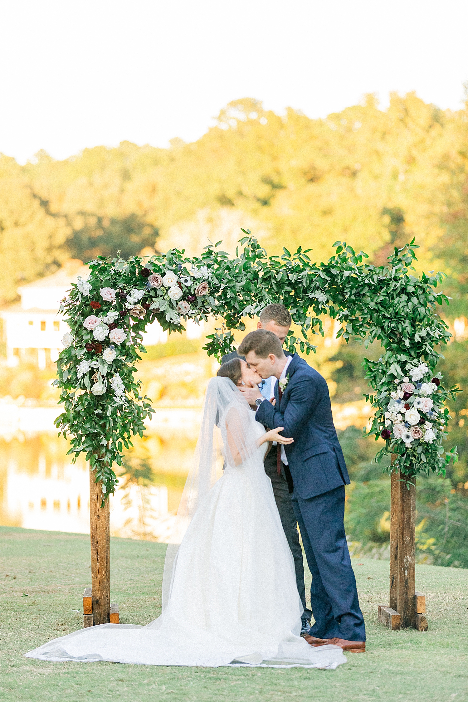 kiss as husband and wife during Riverchase Country Club fall wedding ceremony