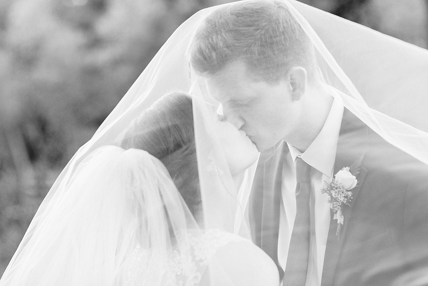 bride and groom kiss under veil at Riverchase Country Club