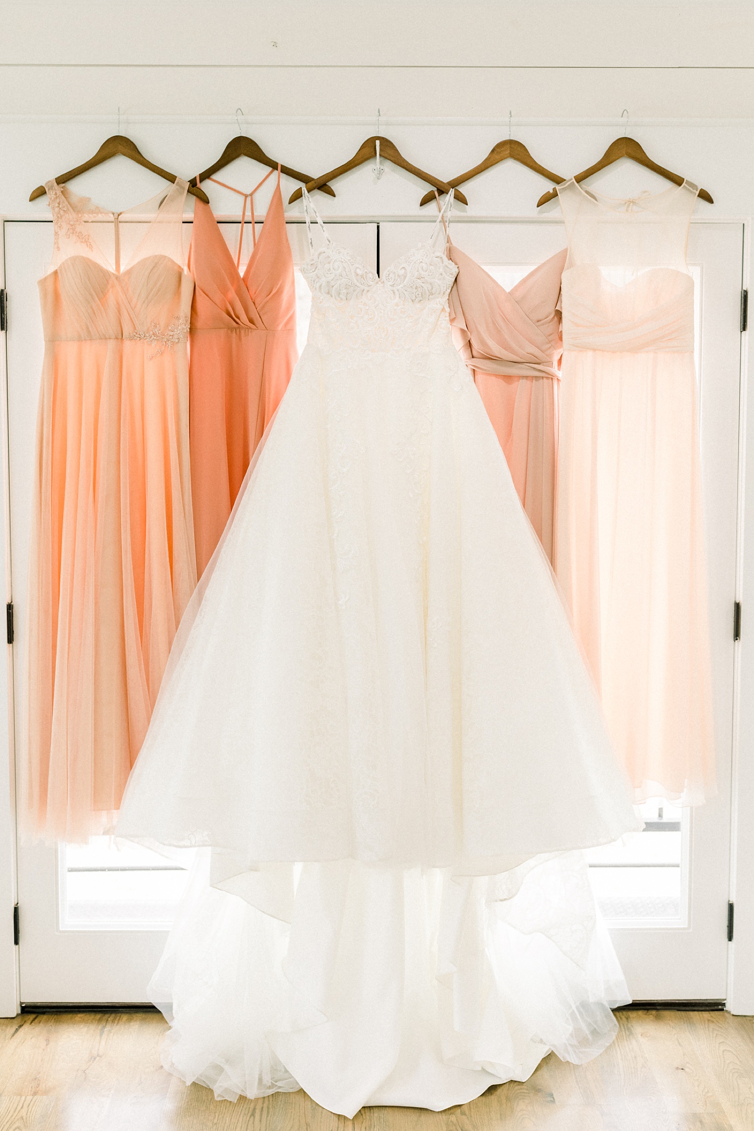 bridal gown hangs with bridesmaid's dresses