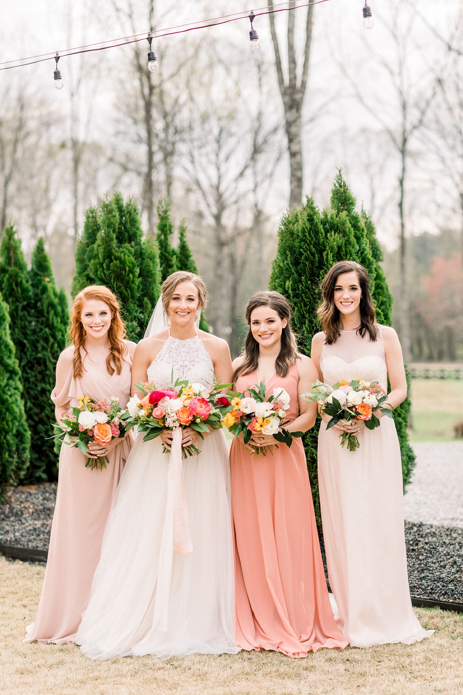 bride and bridesmaids pose together on patio at Oak Meadow Event Center