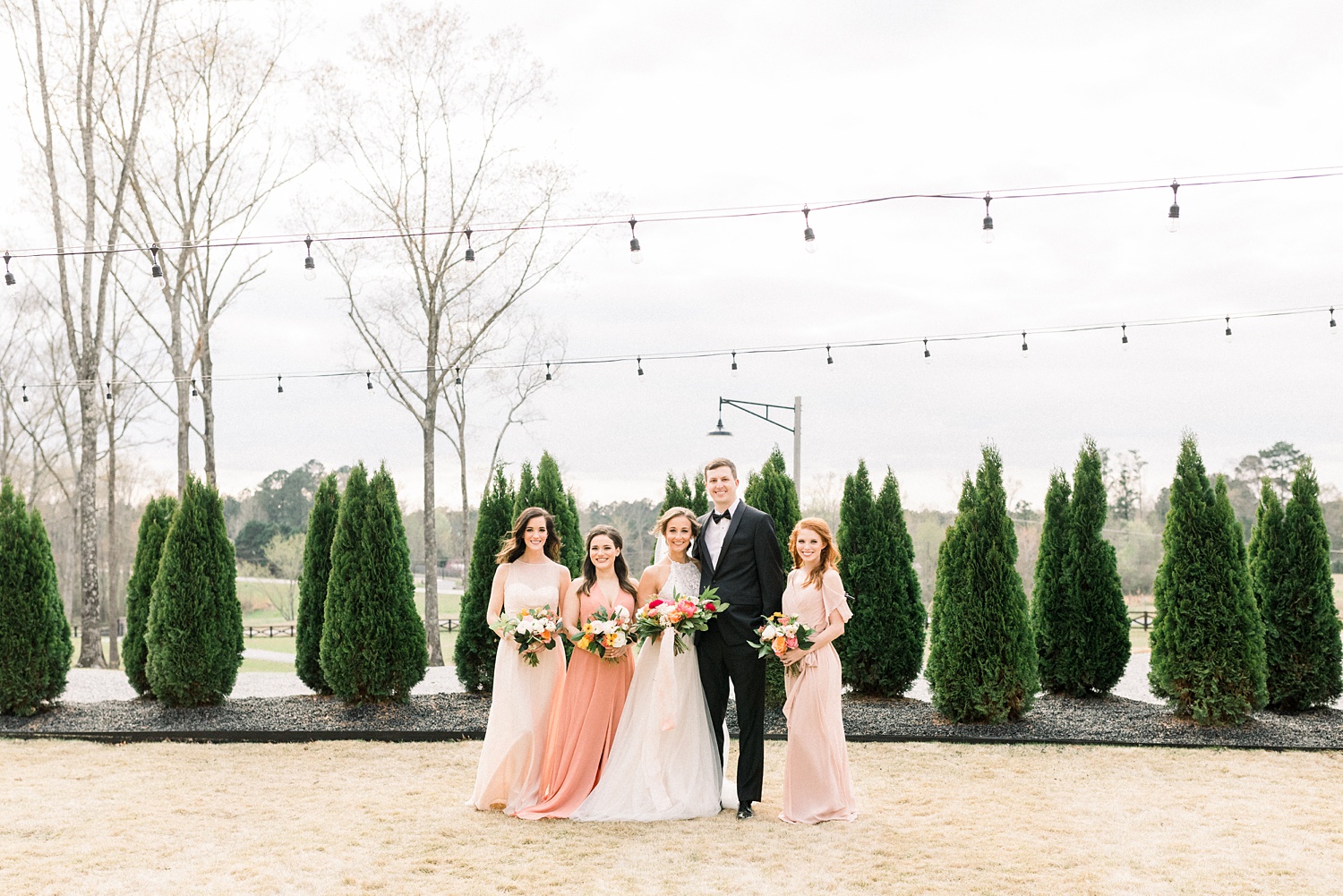 bride and groom pose with bridesmaids in patio at Oak Meadow Event Center