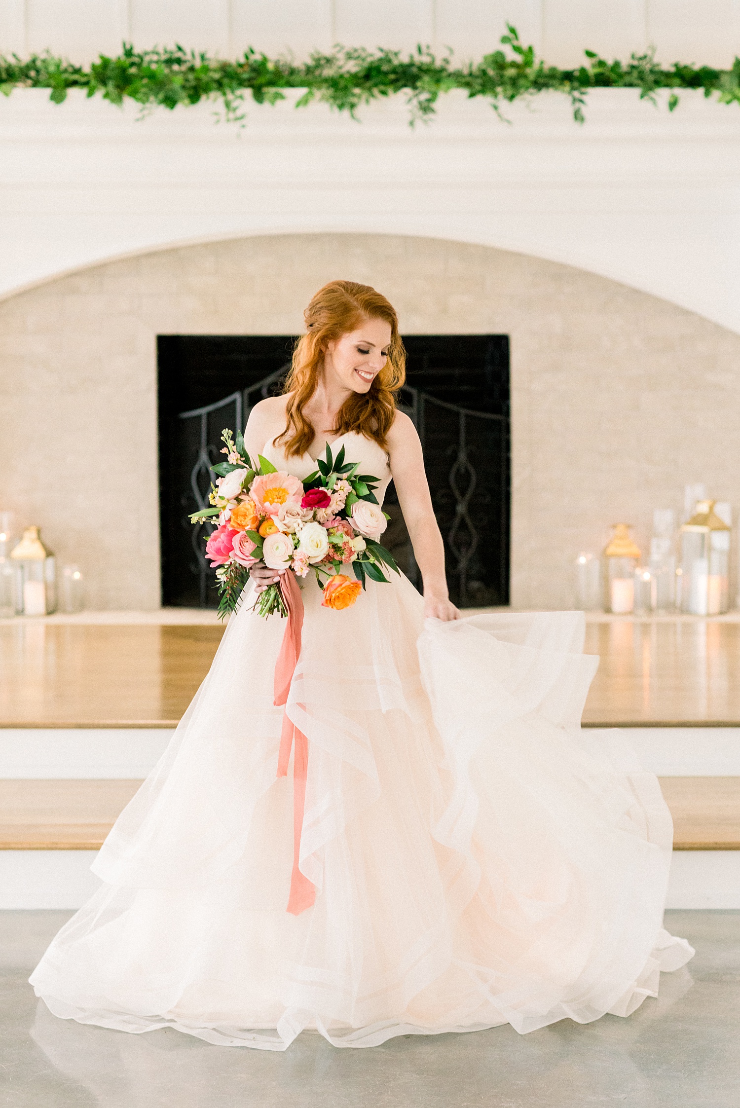 bride in strapless gown twirls dress in front of fireplace