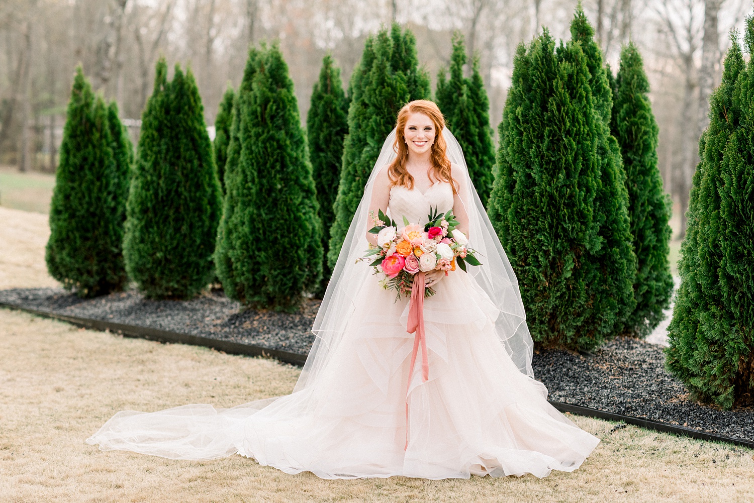 bride with strapless gown and veil holds bouquet