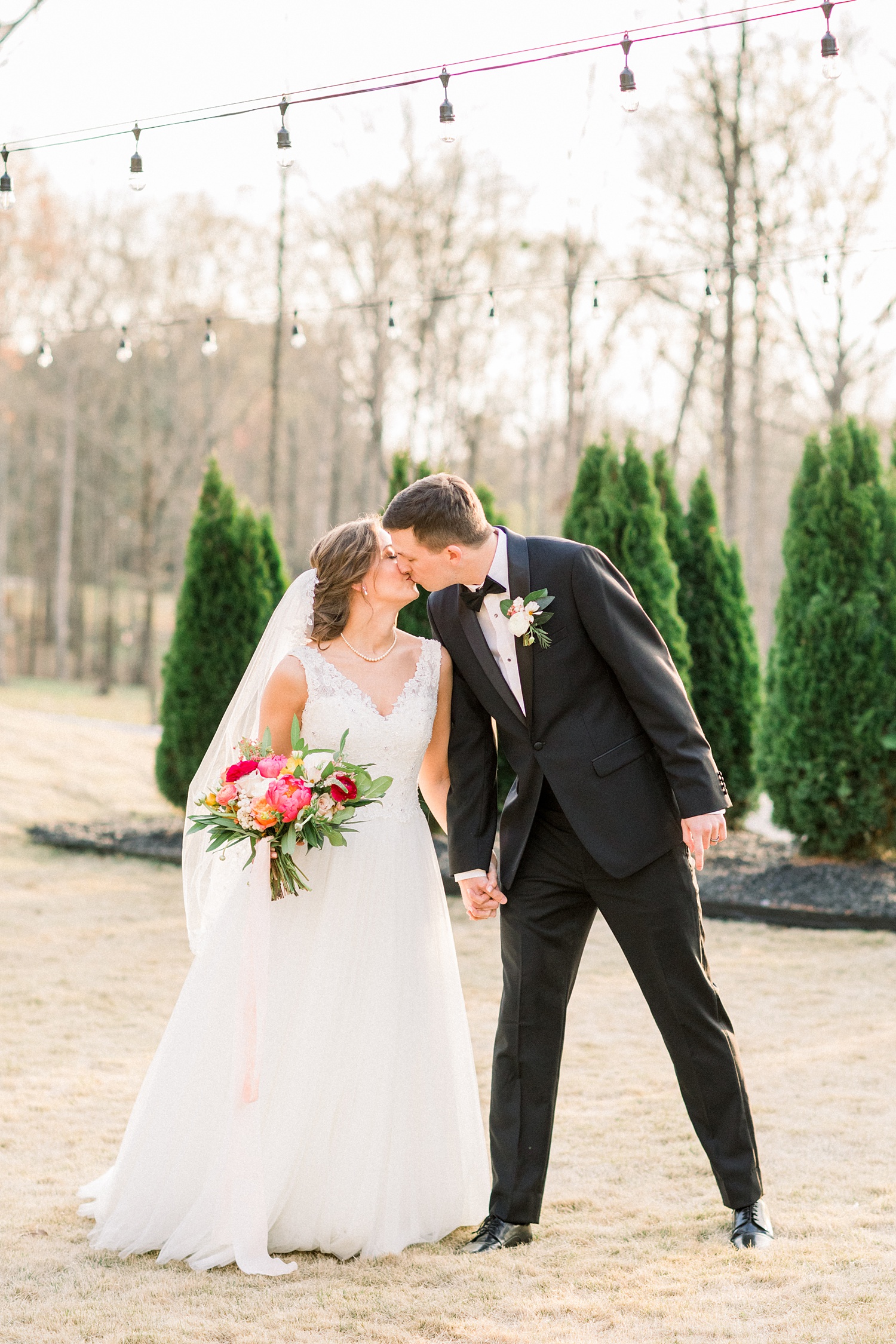 bride and groom kiss on patio at Oak Meadow Event Center
