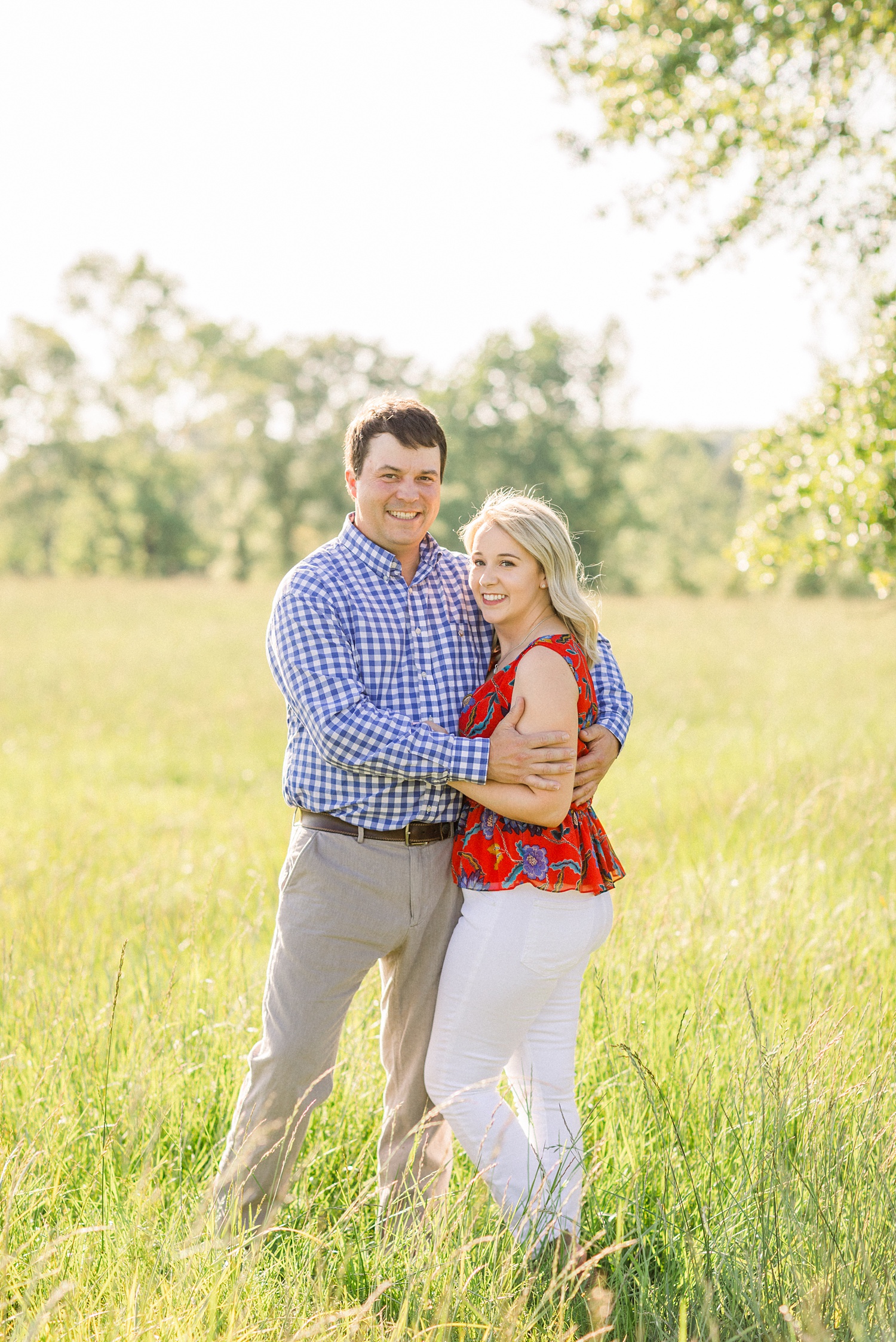 couple hugs in field during Huntsville Alabama engagement photos