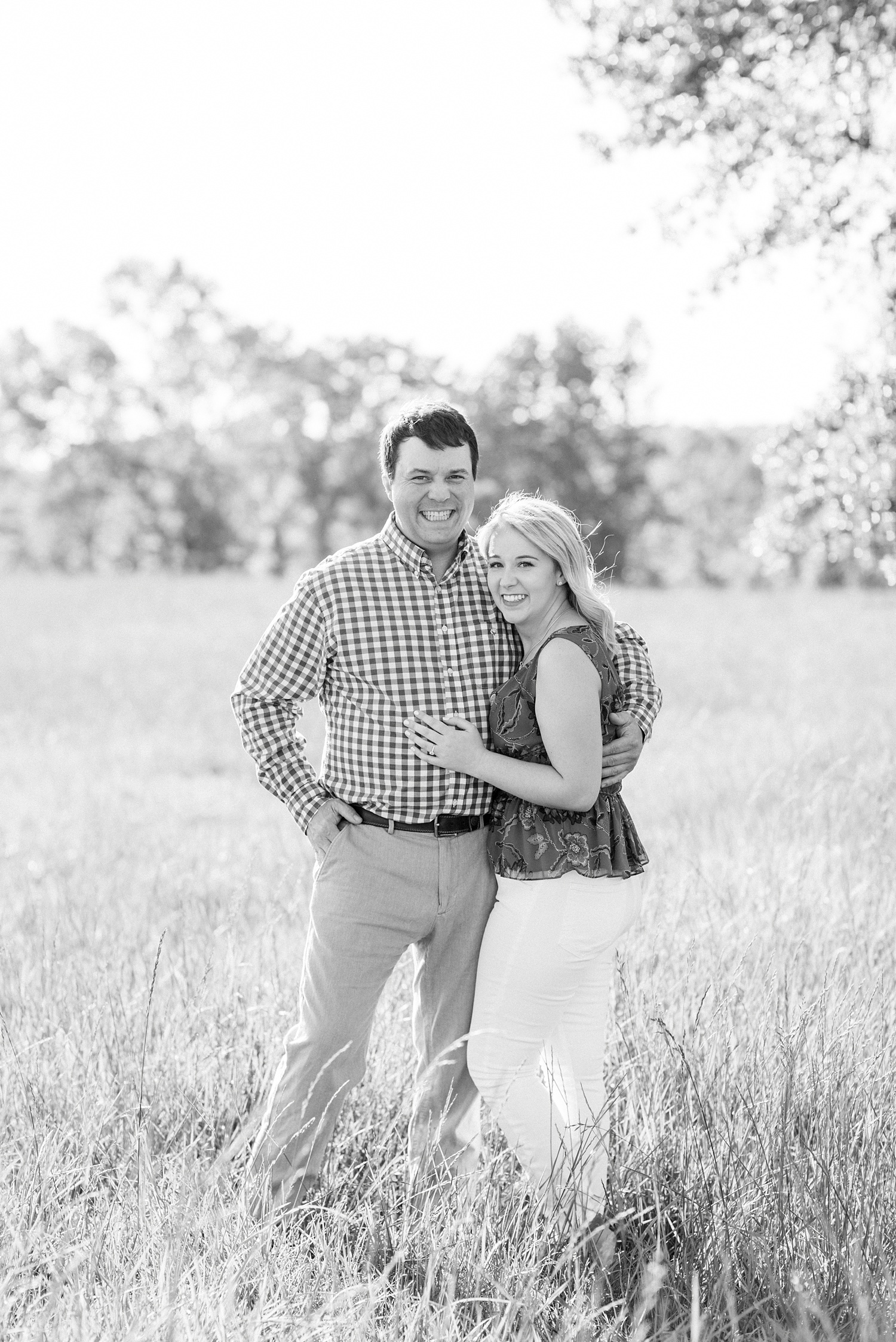 bride and groom pose together in field during Alabama engagement session