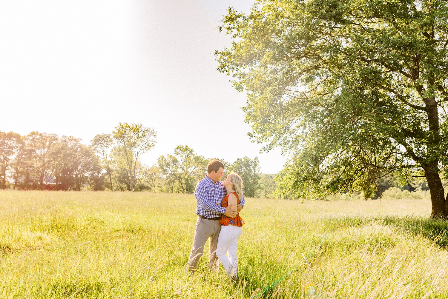 bride and groom pose in field during Huntsville Alabama engagement photos