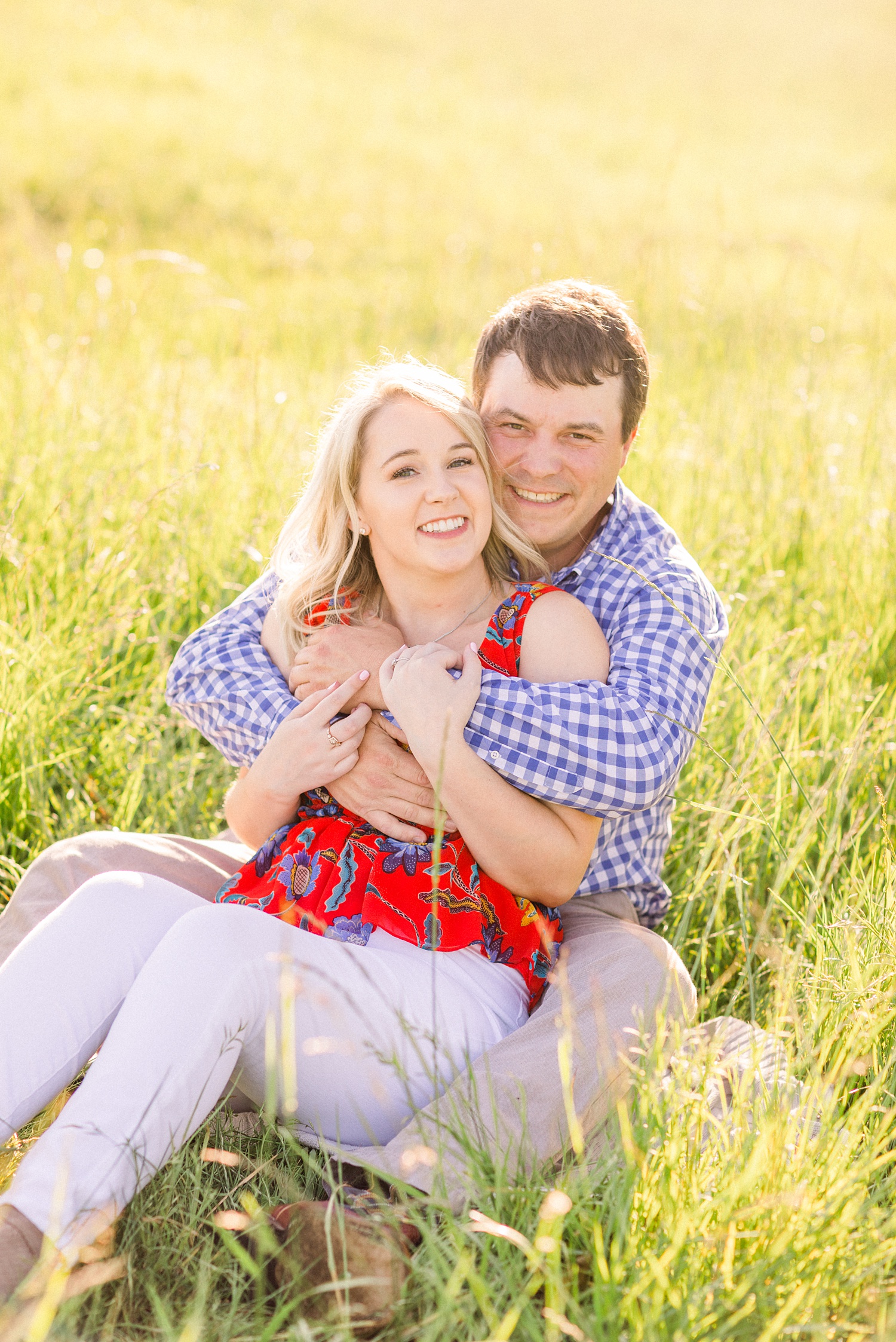 groom hugs bride in field during Alabama engagement session