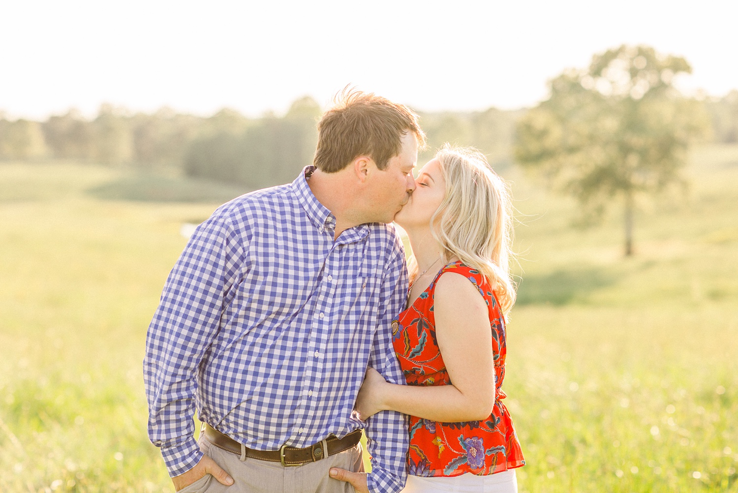 engaged couple kisses in field of Huntsville Alabama farm