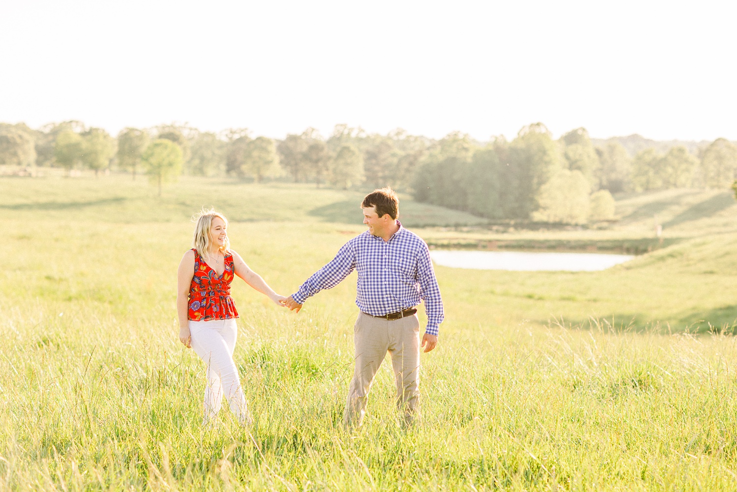 bride and groom hold hands walking through Huntsville Alabama field
